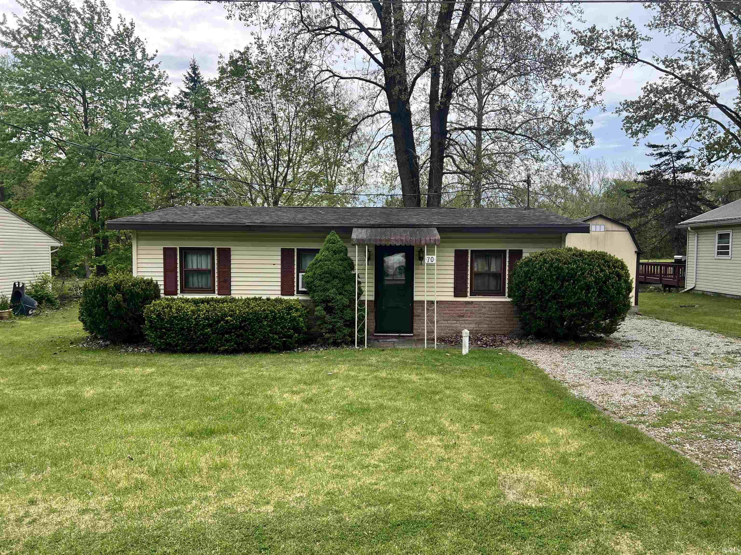Image 0: Cream-colored siding exterior with dark red window shutters, Front Of Structure Image 0: Cream-colored siding exterior with dark red window shutters, Front Of Structure