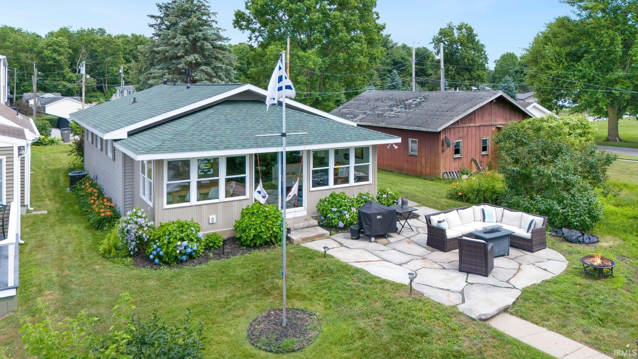 Image 2: Single-story residence featuring a green shingle roof and light-toned siding, Back Of Structure Image 2: Single-story residence featuring a green shingle roof and light-toned siding, Back Of Structure