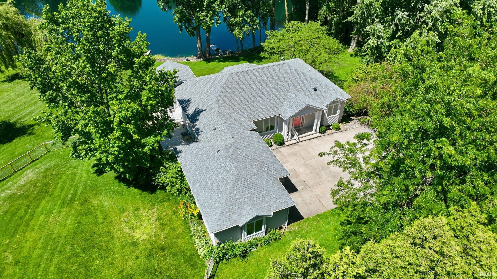 Image 2: Ranch-style residence featuring a gray shingle roof, a concrete driveway, and a front entry with white columns, Aerial View Image 2: Ranch-style residence featuring a gray shingle roof, a concrete driveway, and a front entry with white columns, Aerial View