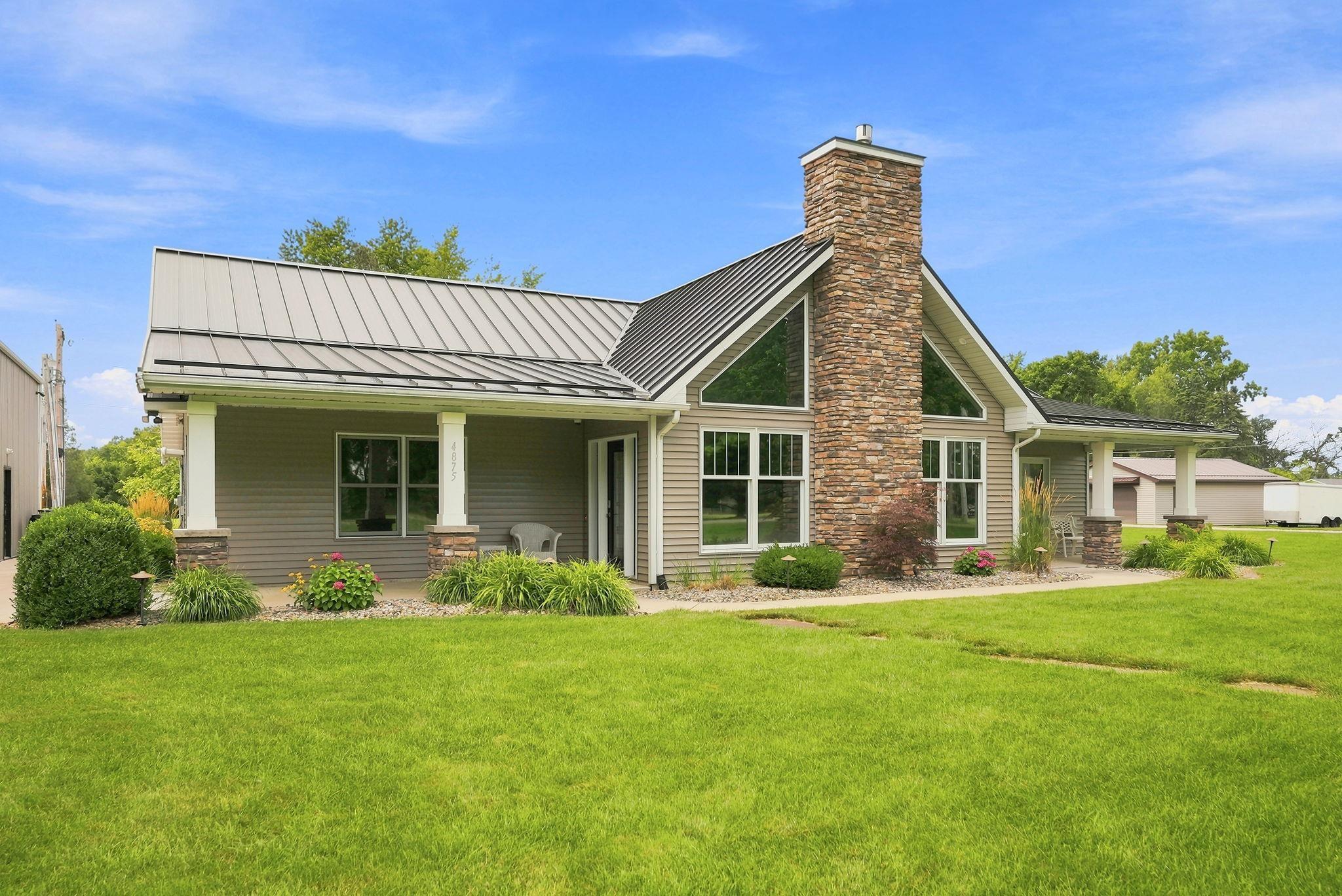 Image 2: Contemporary exterior featuring a stone chimney, a metal roof, and a covered front porch with substantial columns, Back Of Structure Image 2: Contemporary exterior featuring a stone chimney, a metal roof, and a covered front porch with substantial columns, Back Of Structure