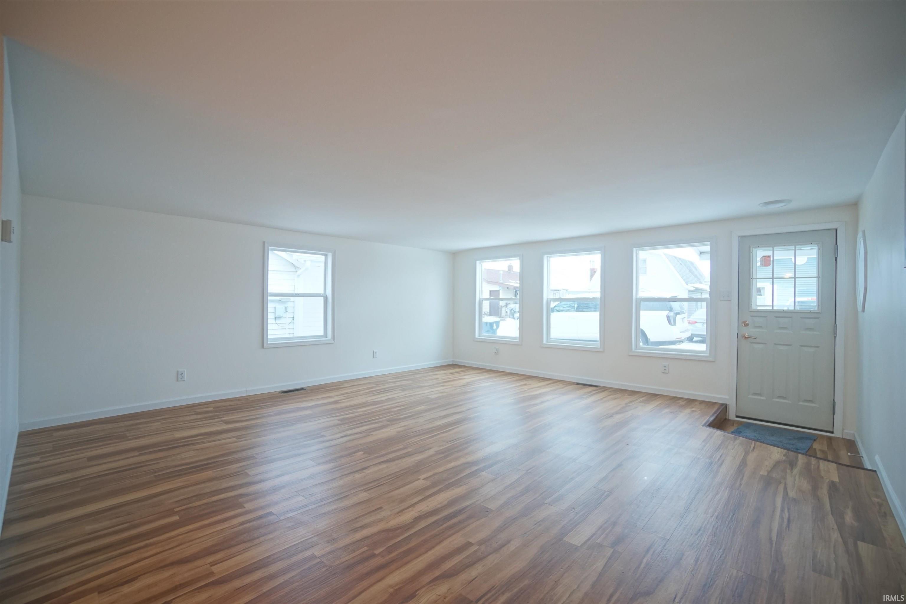 Image 2: Unfurnished living room featuring dark wood-type flooring and baseboards, Living Room Image 2: Unfurnished living room featuring dark wood-type flooring and baseboards, Living Room