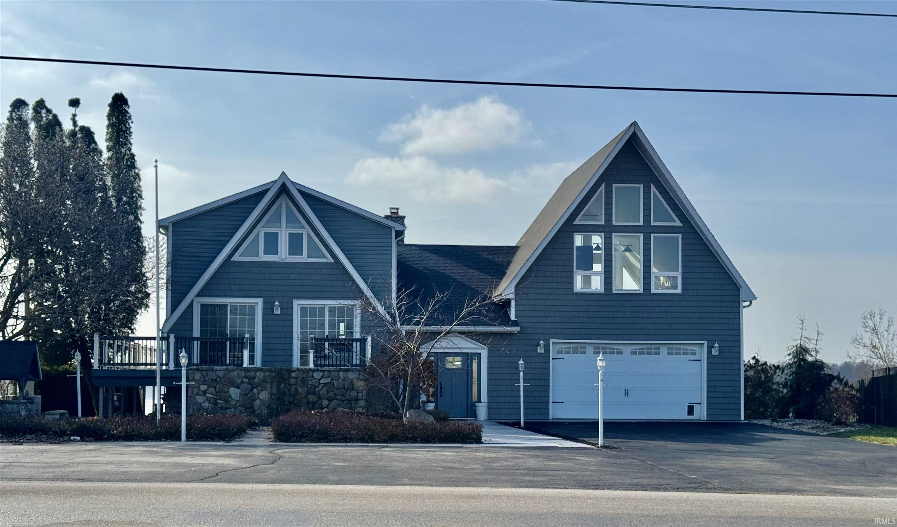 Image 0: A-frame home featuring driveway, a chimney, and an attached garage, Front Of Structure Image 0: A-frame home featuring driveway, a chimney, and an attached garage, Front Of Structure