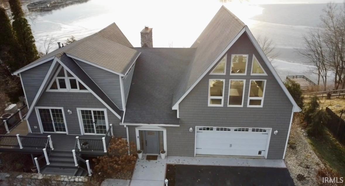 Image 2: View of front of house with an attached garage, a chimney, asphalt driveway, and a shingled roof, Front Of Structure Image 2: View of front of house with an attached garage, a chimney, asphalt driveway, and a shingled roof, Front Of Structure