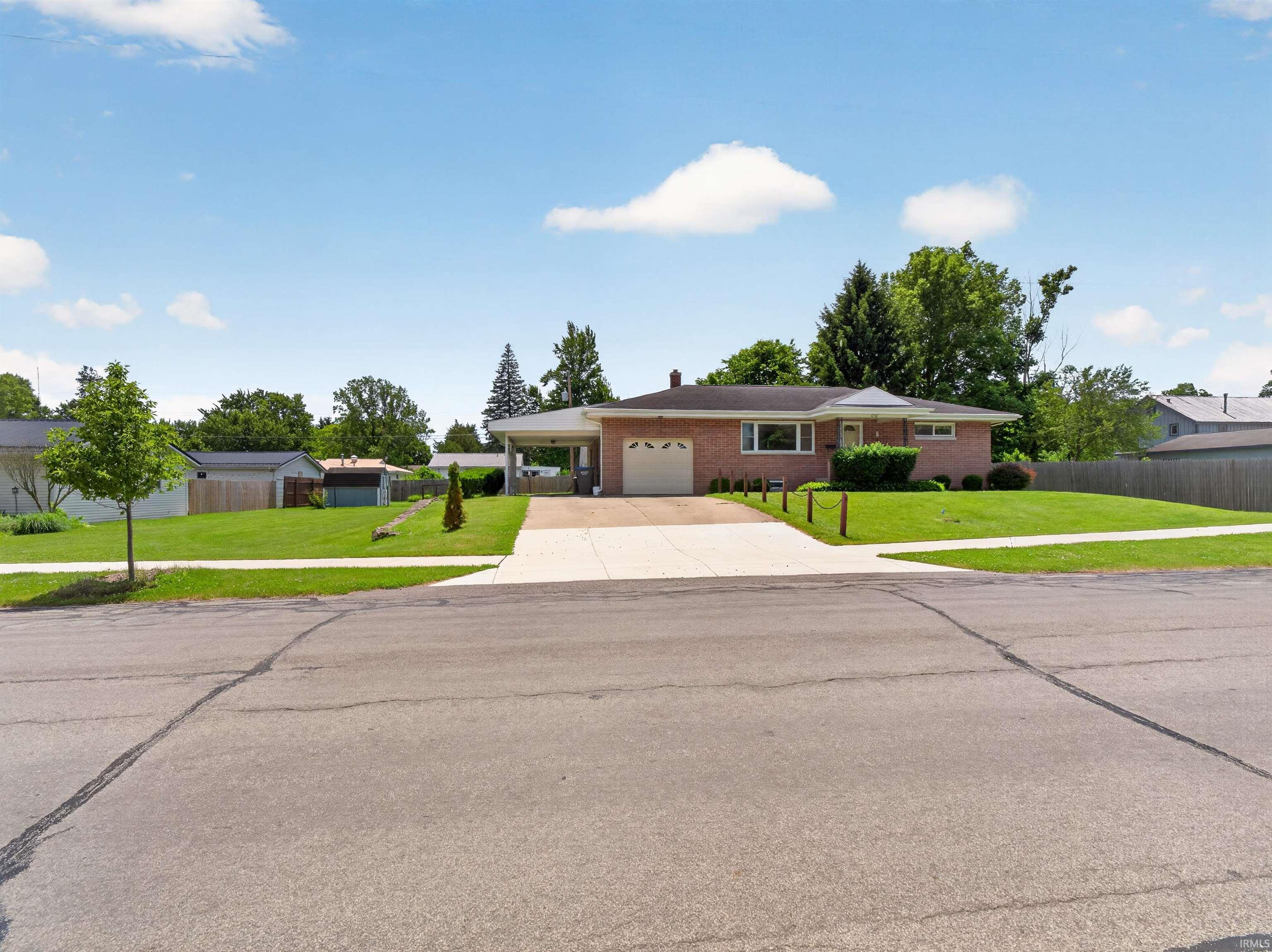 Image 2: Brick ranch-style home featuring an attached carport, an integrated garage, and a concrete driveway, Front Of Structure