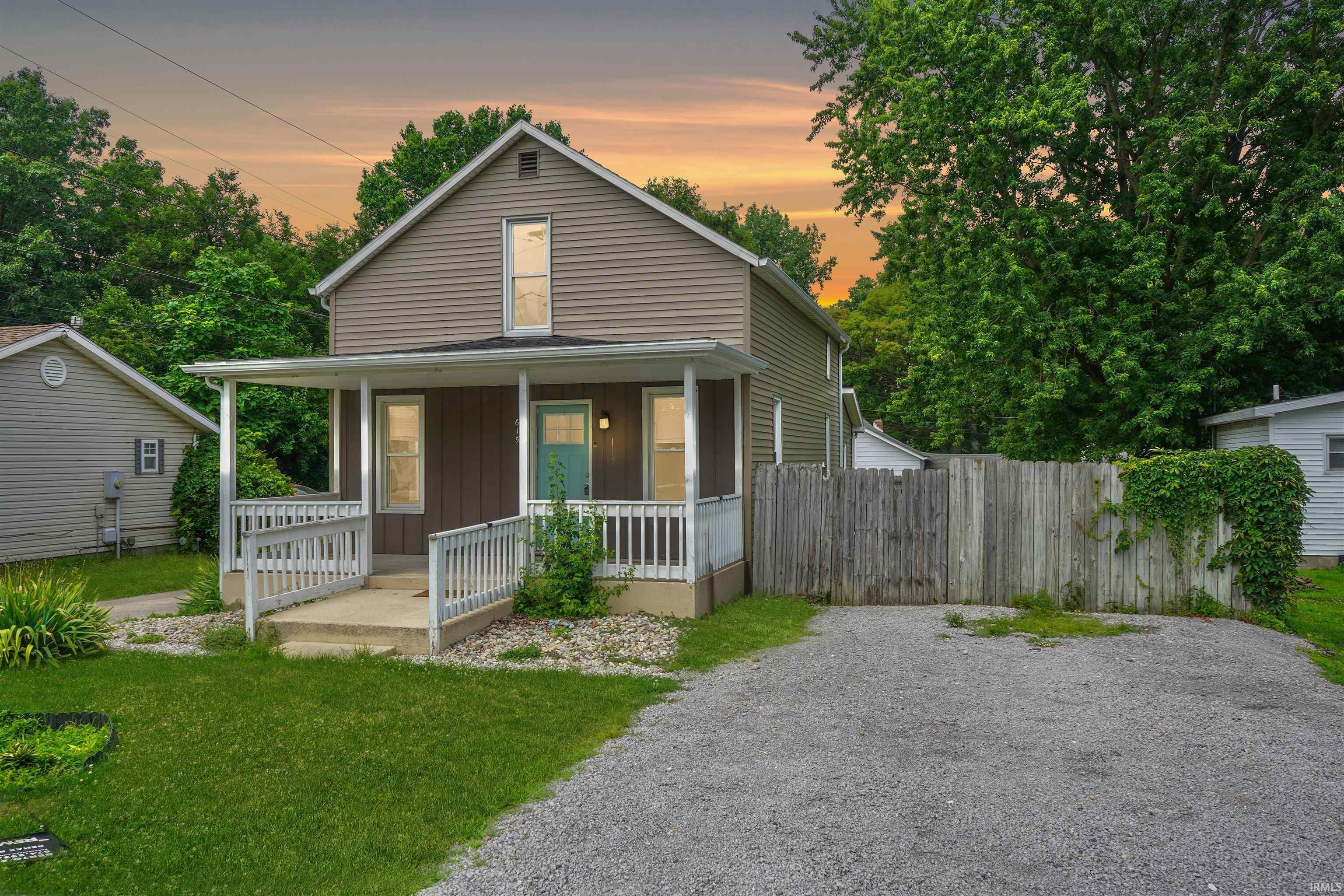 Image 0: Two-story residence featuring horizontal siding and a covered front porch with white railing, Front Of Structure