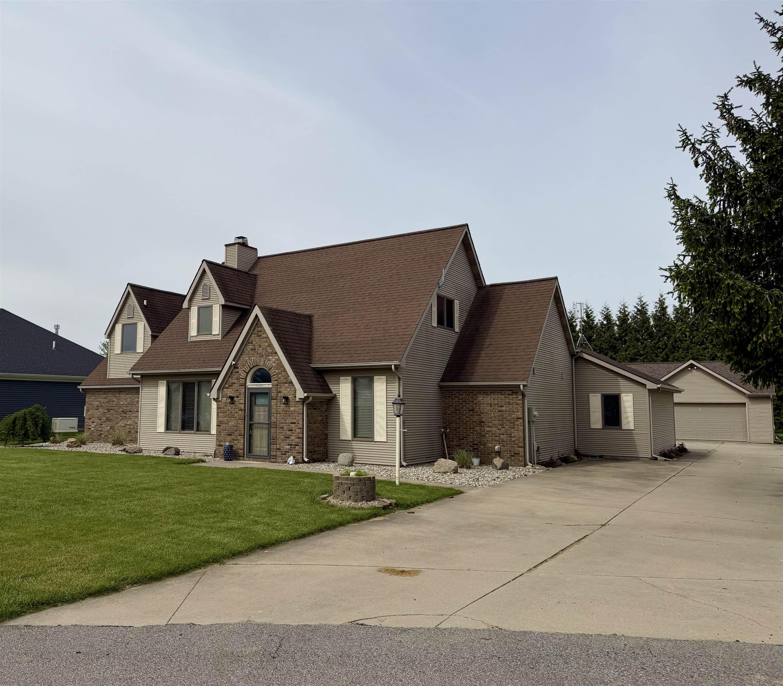 Image 1: Architectural residence featuring a stone and siding facade, multiple gables, and a prominent front entrance with an arched stone surround, Front Of Structure
