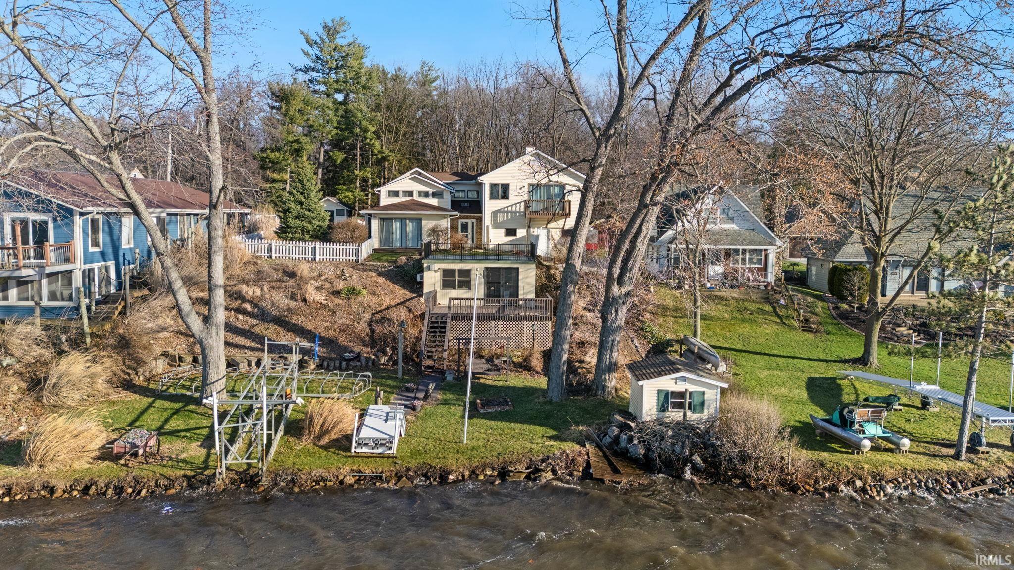 Image 3: Aerial perspective of suburban area with a nearby body of water and a tree filled landscape, Aerial View
