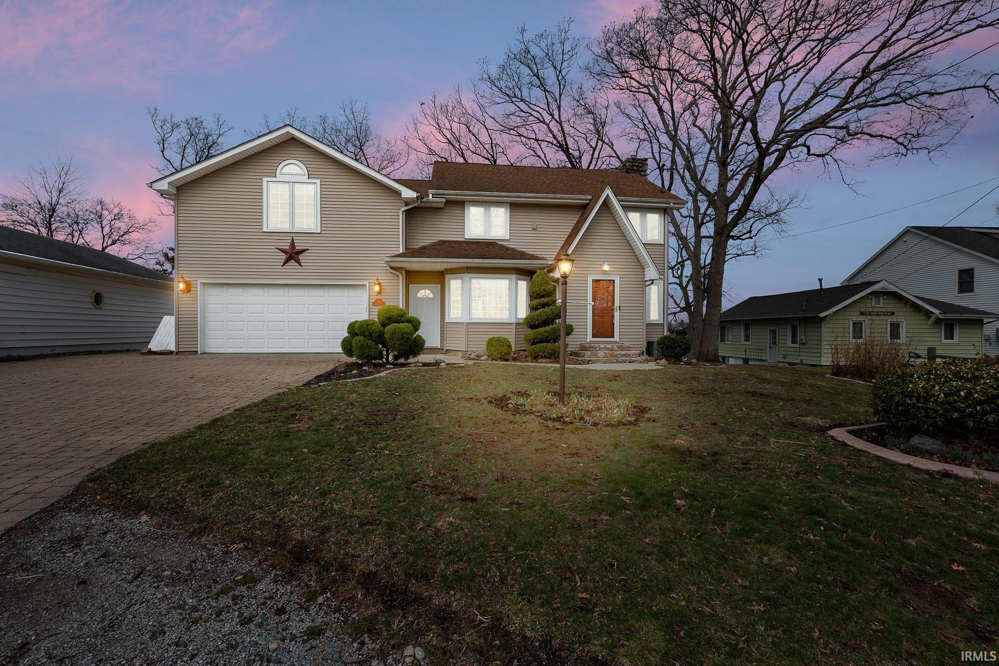 Image 1: Traditional home with a garage, decorative driveway, a chimney, and a yard, Front Of Structure Image 1: Traditional home with a garage, decorative driveway, a chimney, and a yard, Front Of Structure