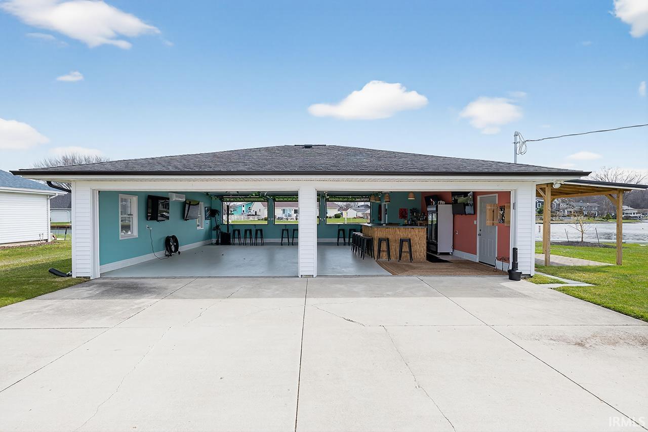 Image 3: View of front of property featuring a garage, roof with shingles, driveway, and a front yard, Front Of Structure