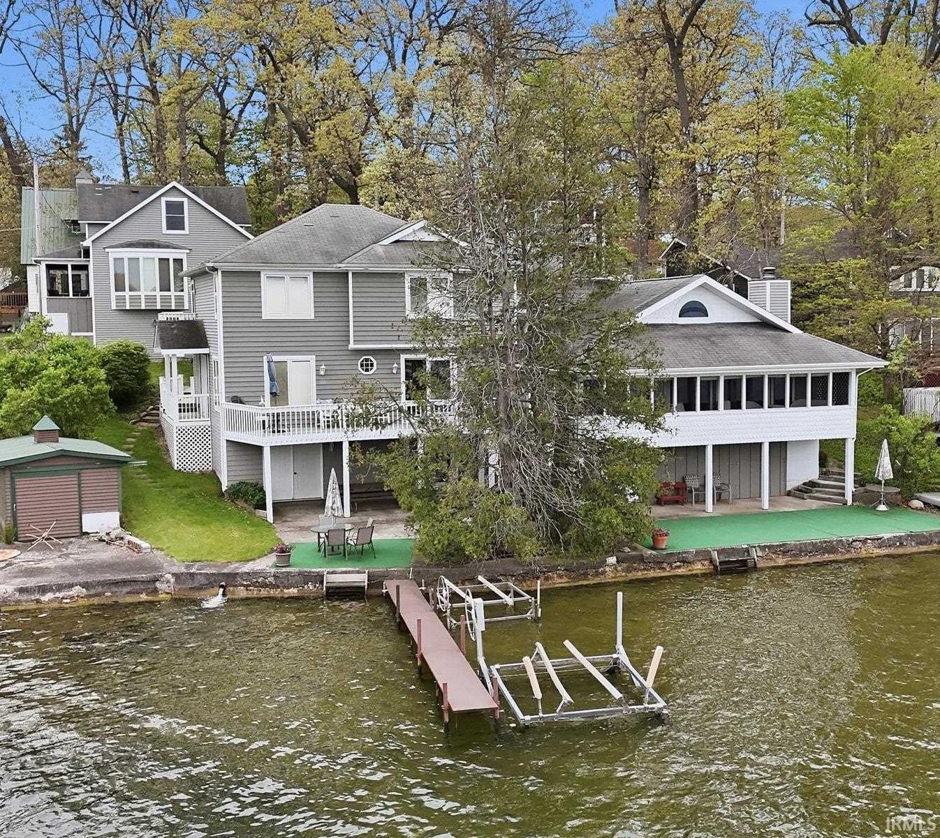 Image 0: Waterfront property featuring a multi-level structure with multiple balconies, a covered patio, and a private dock