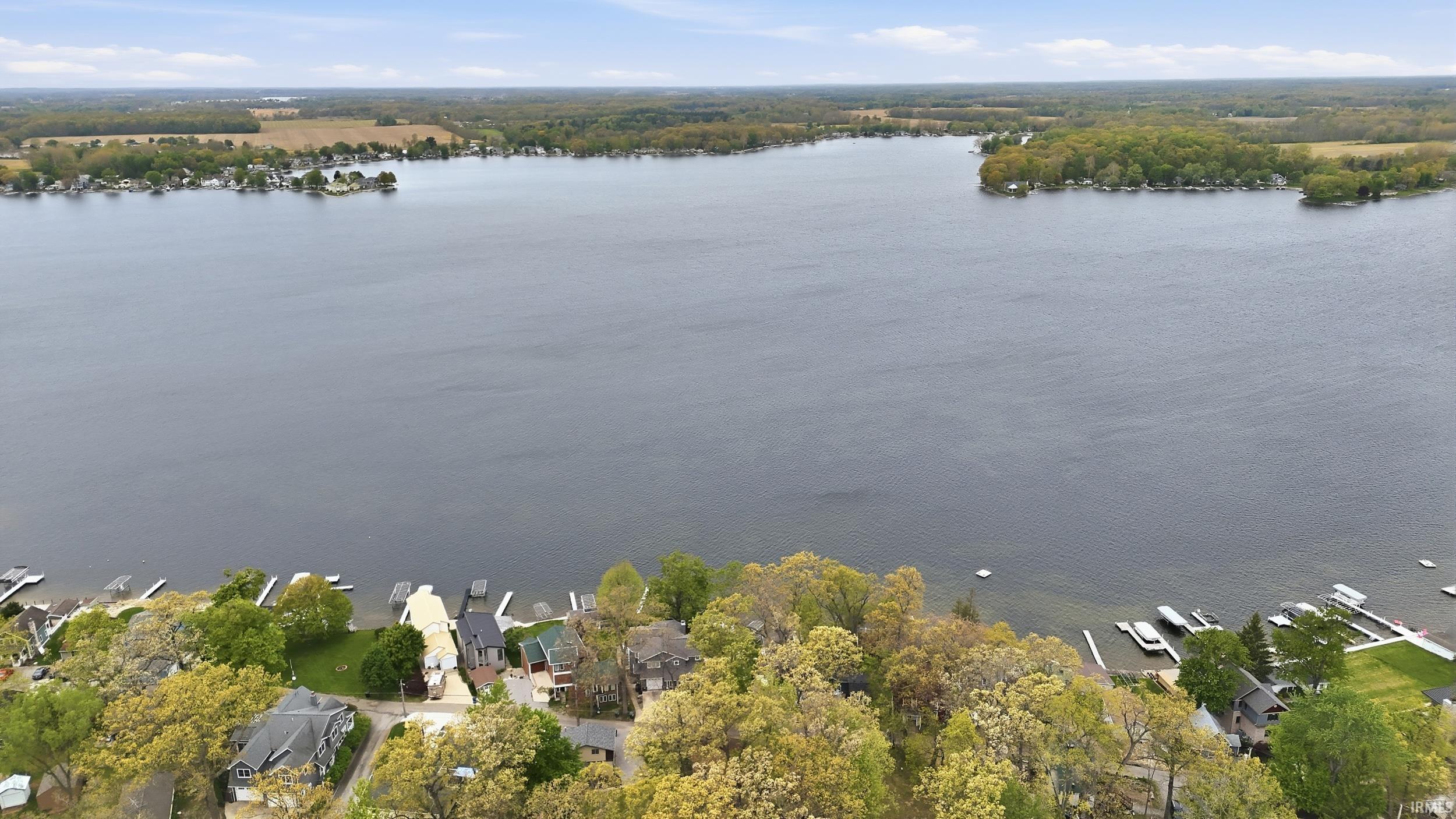 Image 3: Expansive lake with a tree-lined shoreline and residential properties, Aerial View