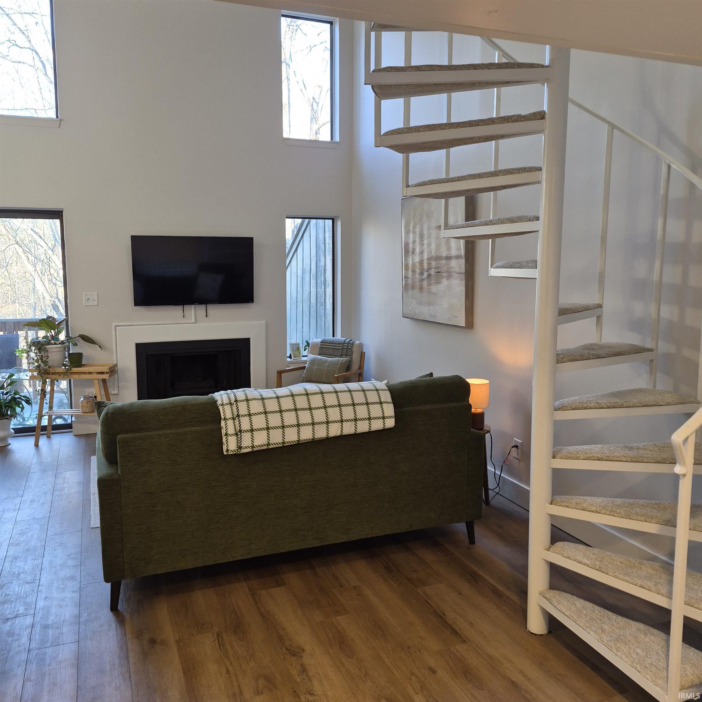Image 3: Living room featuring a fireplace, a high ceiling, dark wood-type flooring, and plenty of natural light, Living Room Image 3: Living room featuring a fireplace, a high ceiling, dark wood-type flooring, and plenty of natural light, Living Room