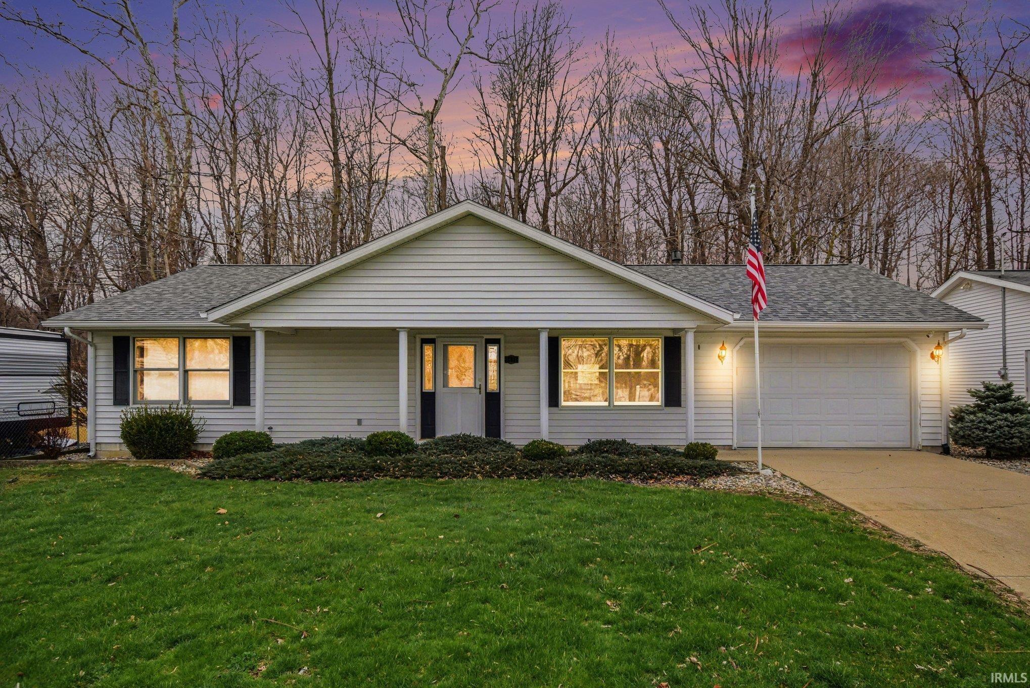 Image 0: View of front of home featuring roof with shingles, an attached garage, a porch, a front yard, and driveway, Front Of Structure