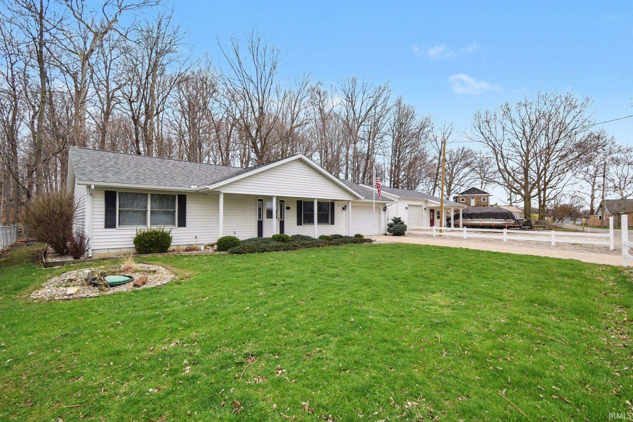 Image 1: Single story home with a garage, concrete driveway, a porch, and roof with shingles, Front Of Structure