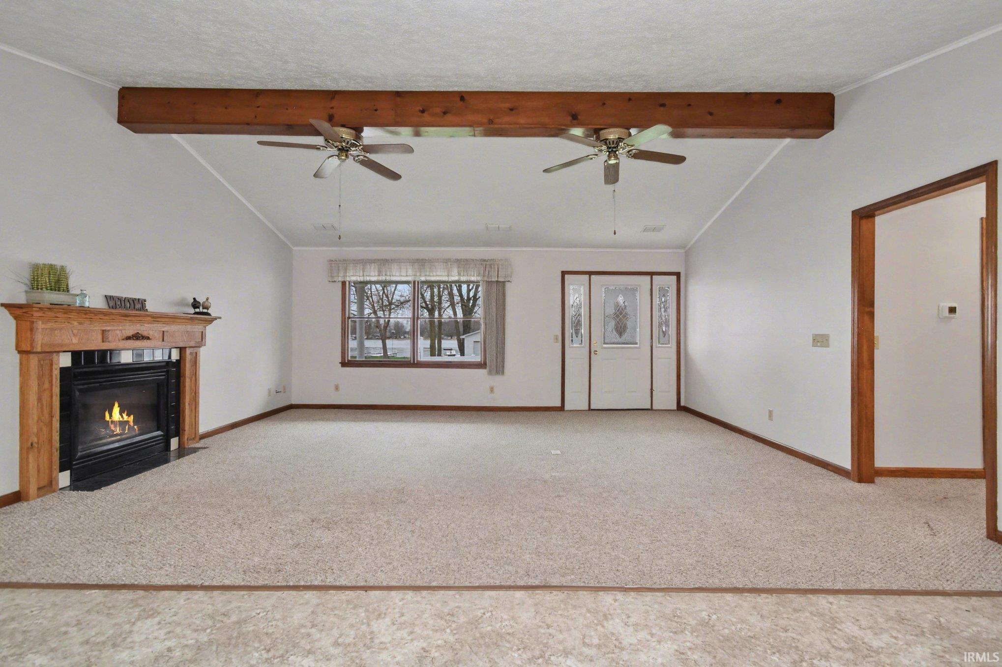 Image 2: Unfurnished living room with beamed ceiling, a fireplace with flush hearth, and light carpet, Living Room