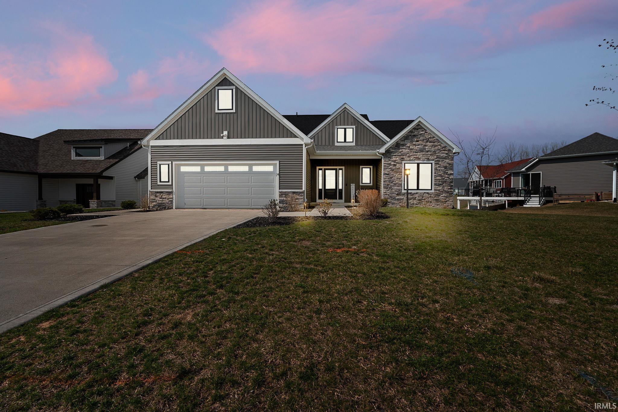 Image 0: Craftsman house featuring stone siding, a yard, concrete driveway, and board and batten siding, Front Of Structure Image 0: Craftsman house featuring stone siding, a yard, concrete driveway, and board and batten siding, Front Of Structure