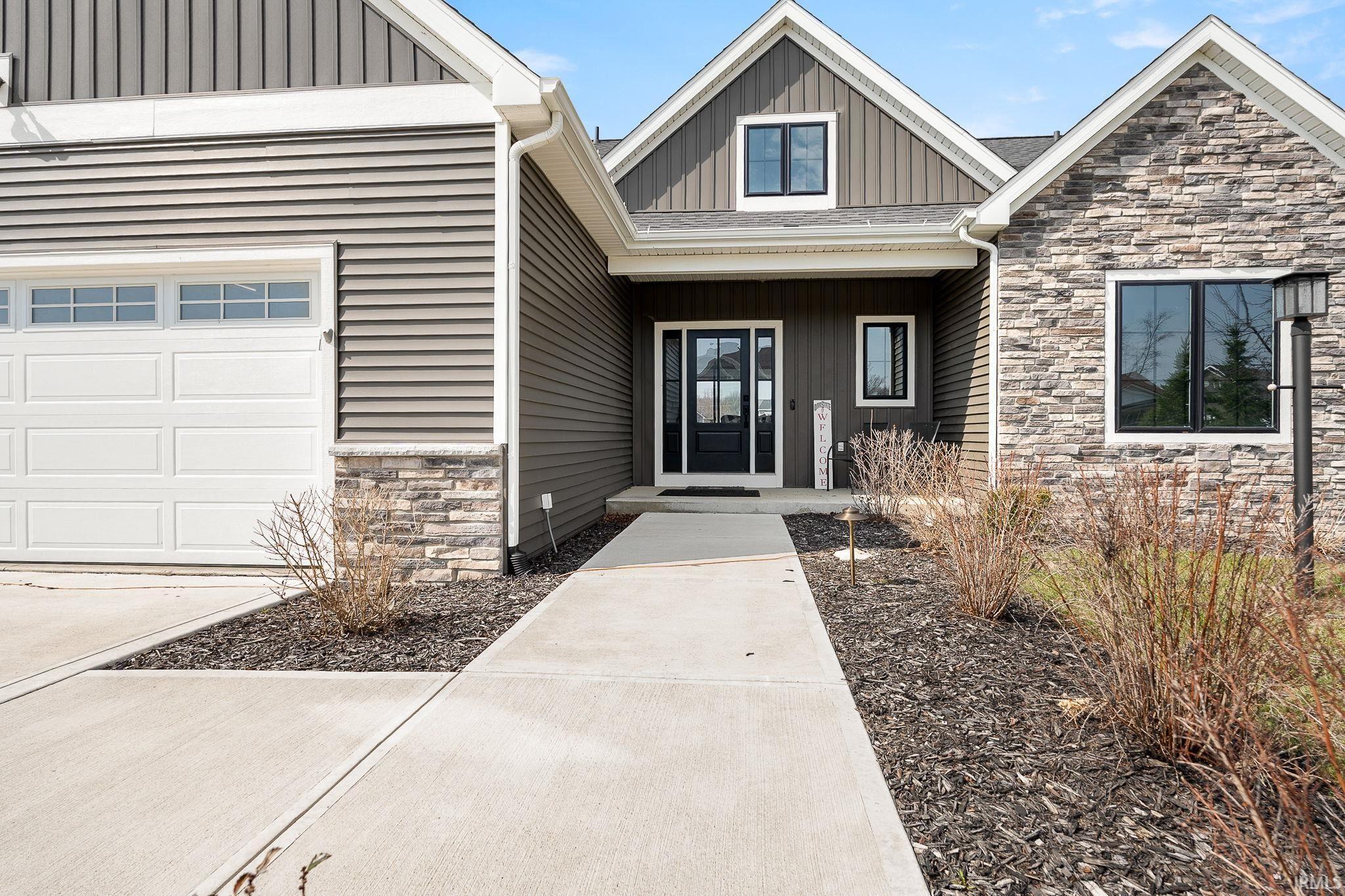 Image 3: Property entrance with board and batten siding, stone siding, and covered porch, Entry Image 3: Property entrance with board and batten siding, stone siding, and covered porch, Entry