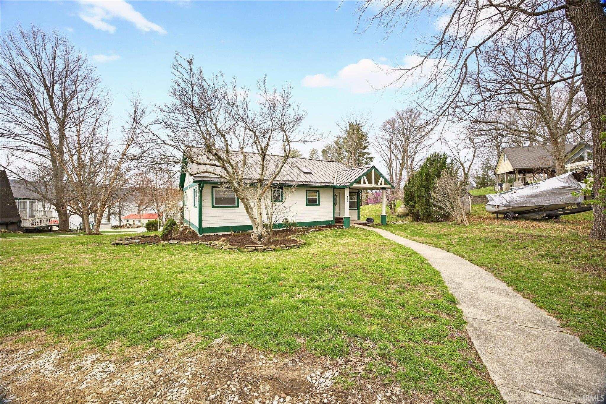 Image 3: View of front facade with a metal roof and a front yard, Front Of Structure Image 3: View of front facade with a metal roof and a front yard, Front Of Structure