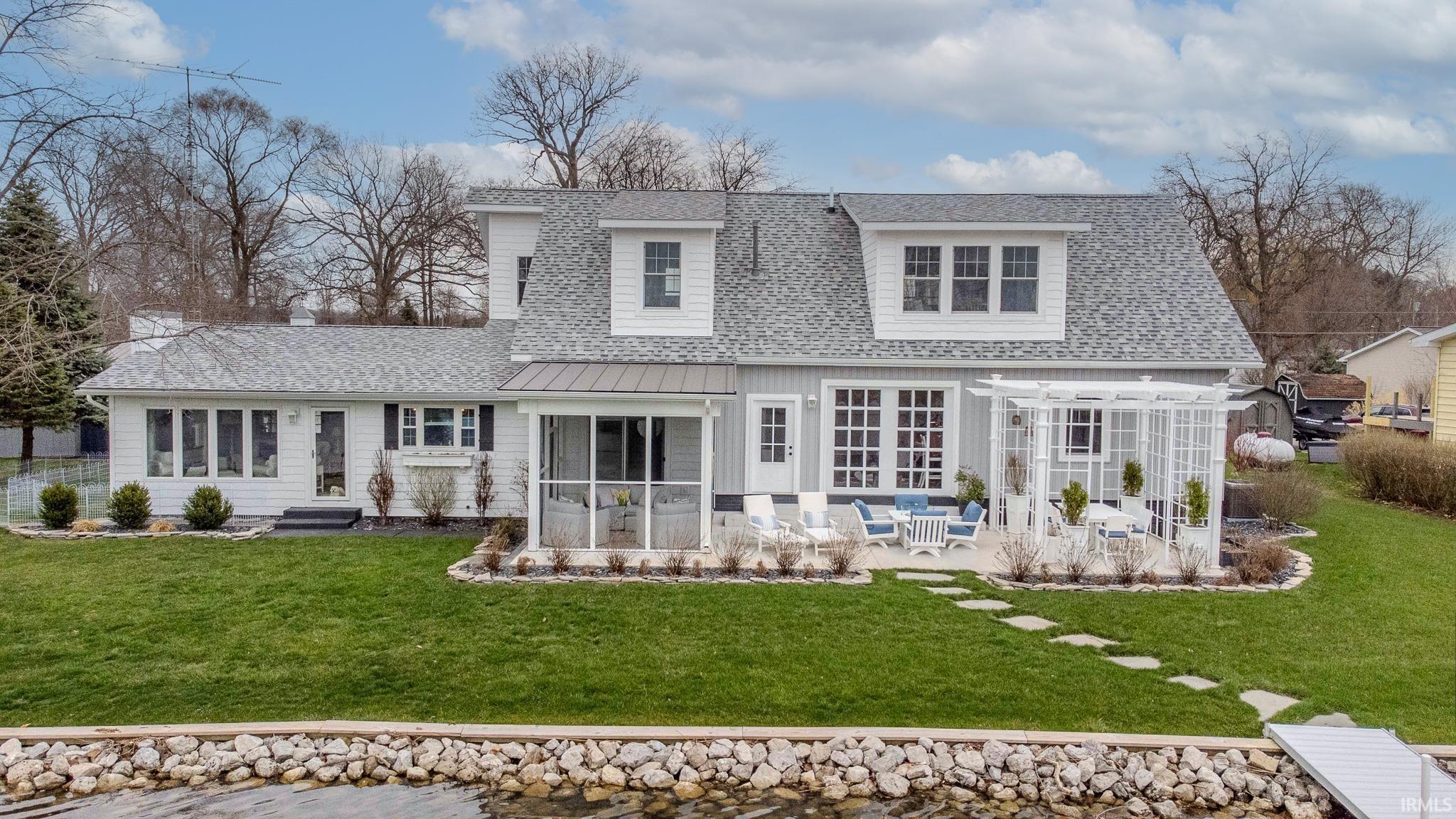 Image 0: Back of property with roof with shingles, a lawn, a patio, and a sunroom, Back Of Structure Image 0: Back of property with roof with shingles, a lawn, a patio, and a sunroom, Back Of Structure