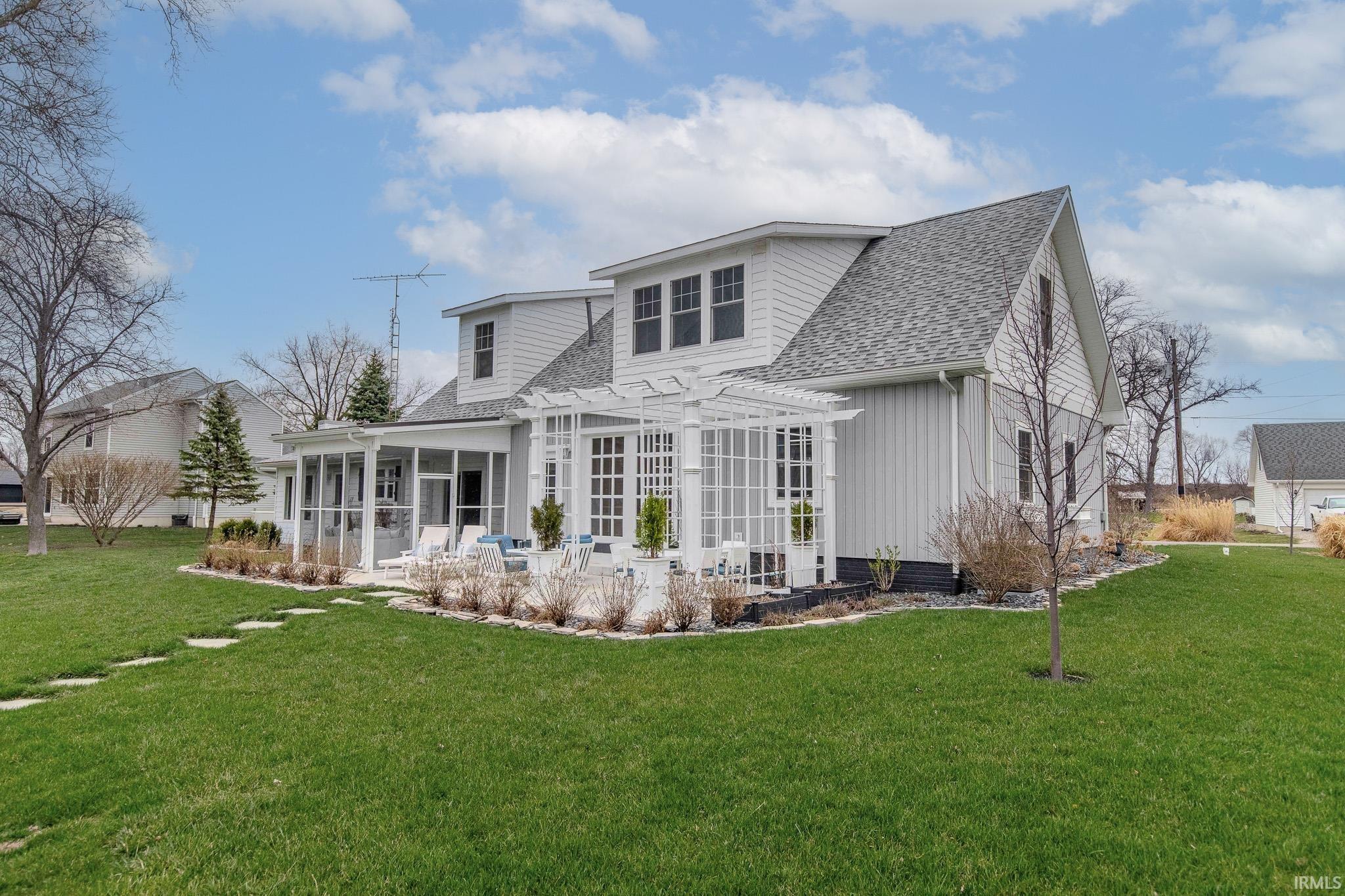 Image 3: Rear view of property featuring a sunroom, roof with shingles, a yard, and a pergola, Back Of Structure Image 3: Rear view of property featuring a sunroom, roof with shingles, a yard, and a pergola, Back Of Structure