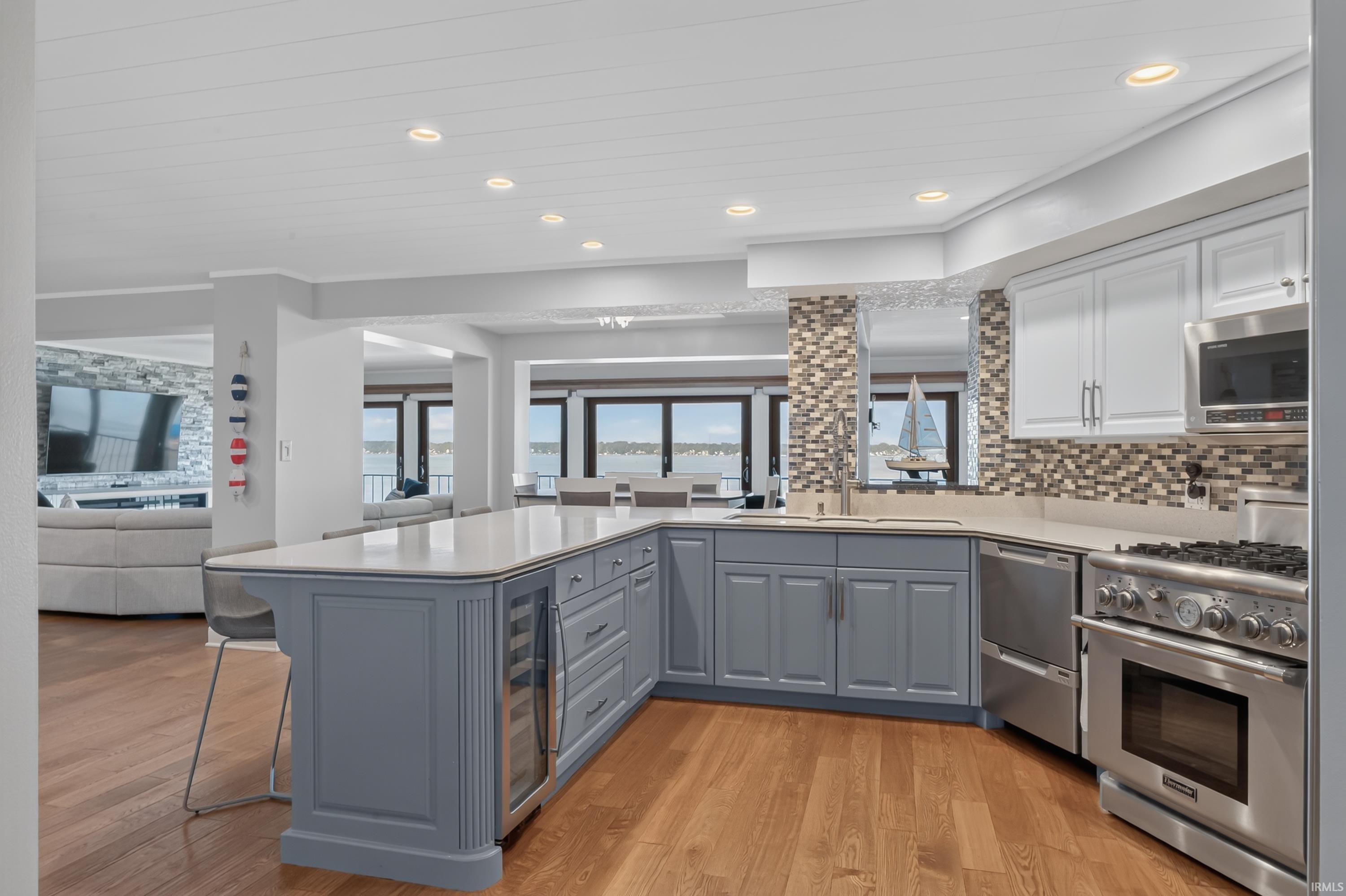 Image 2: Kitchen featuring wood-finish flooring, recessed lighting, and a multi-tone tile backsplash, Kitchen