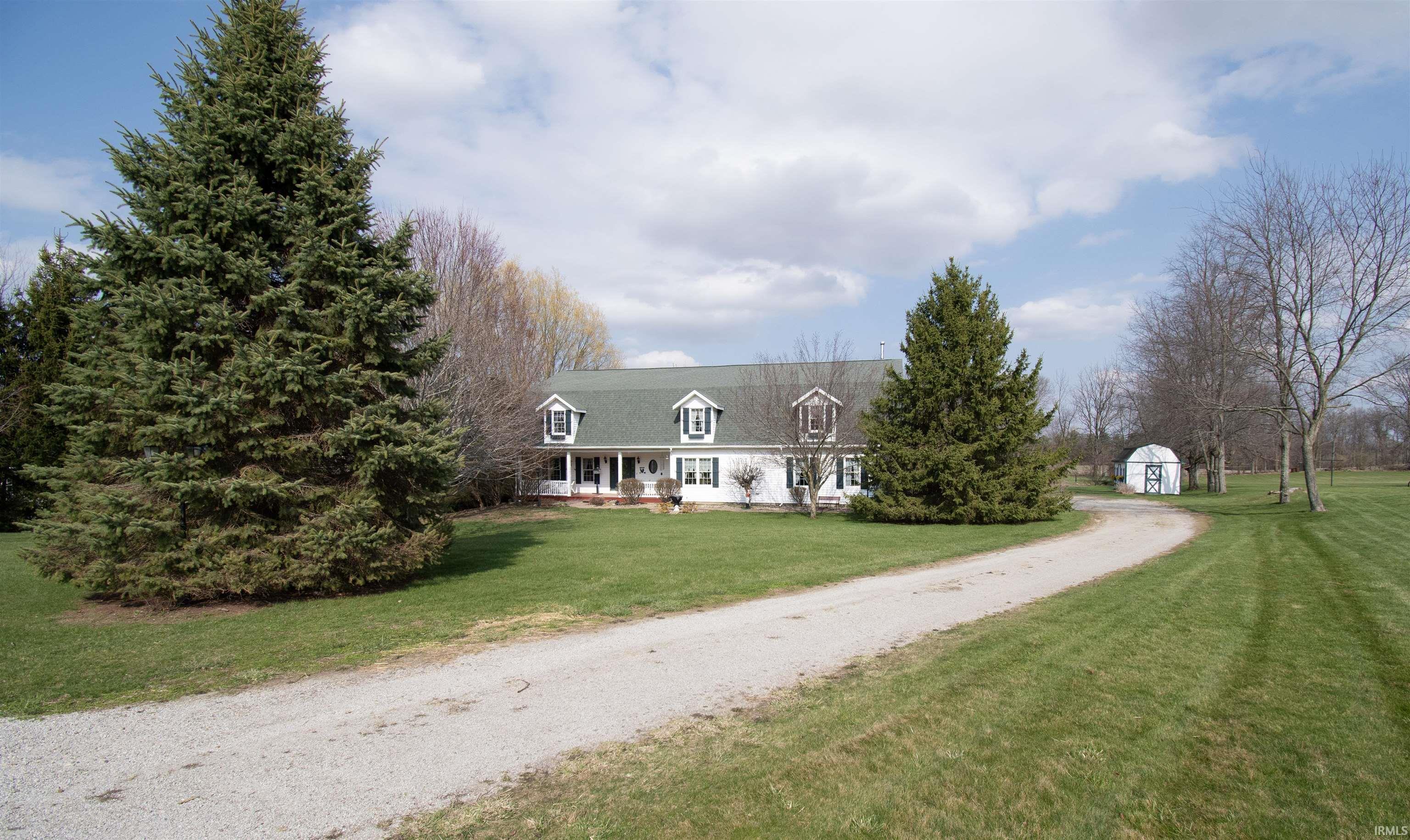 Image 1: View of front of home with a porch, a front yard, dirt driveway, and a storage unit, Front Of Structure