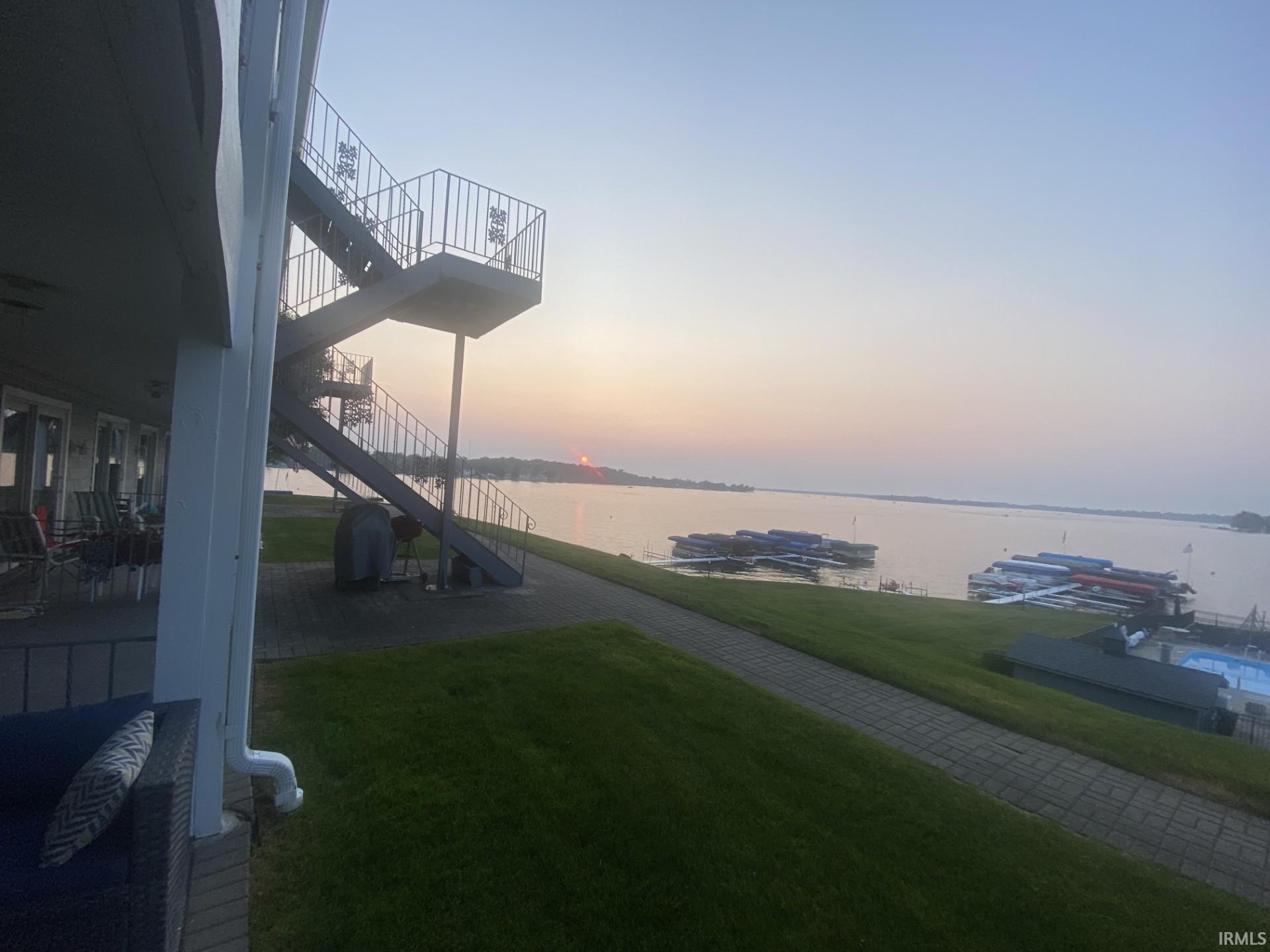 Image 1: Yard at dusk with a water view, a yard, and a patio area, Yard