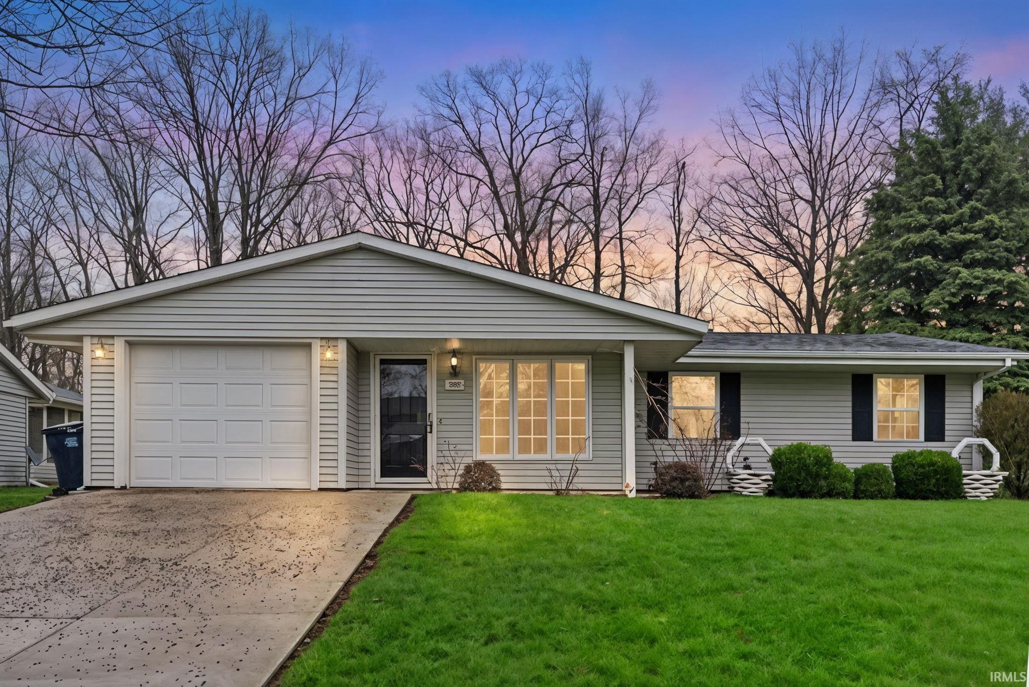 Image 0: Ranch-style house featuring a garage, concrete driveway, a lawn, and a porch, Front Of Structure