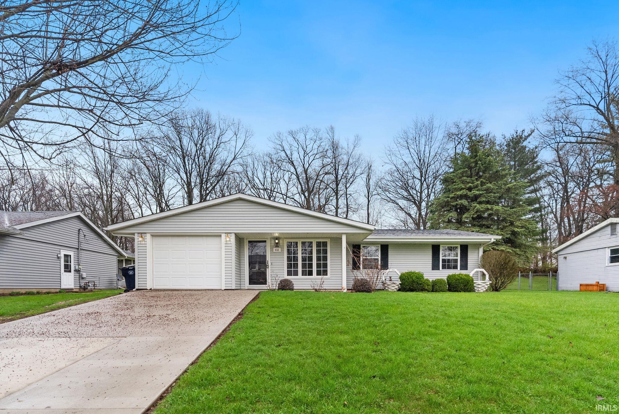 Image 1: Ranch-style home with a front lawn, a garage, and driveway, Front Of Structure