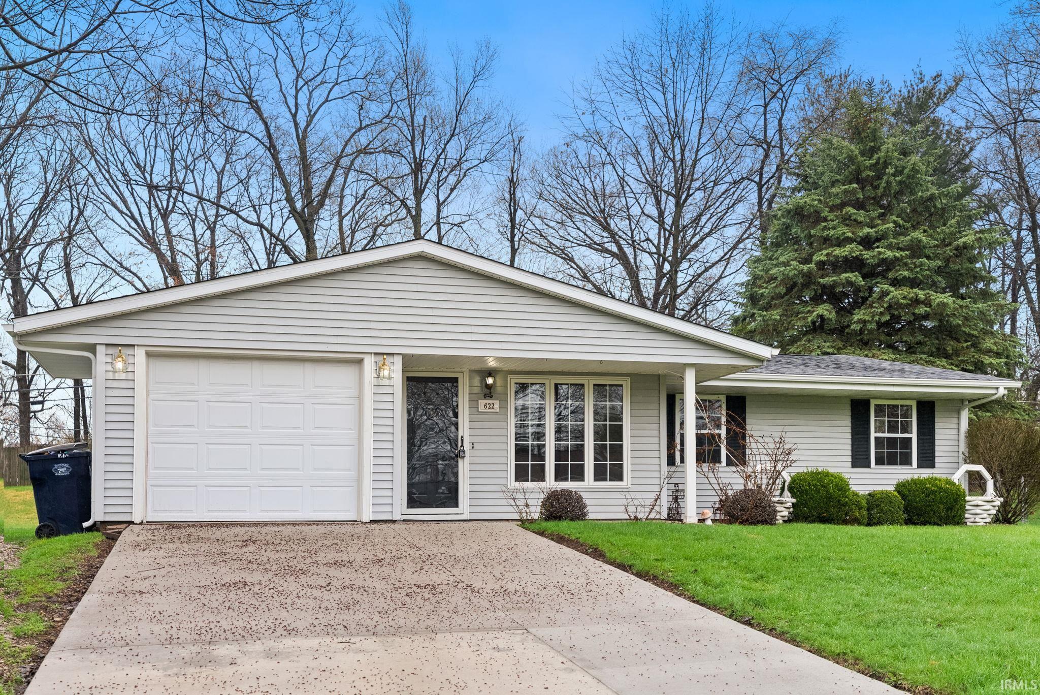 Image 3: Ranch-style house featuring a front lawn, concrete driveway, an attached garage, and covered porch, Front Of Structure