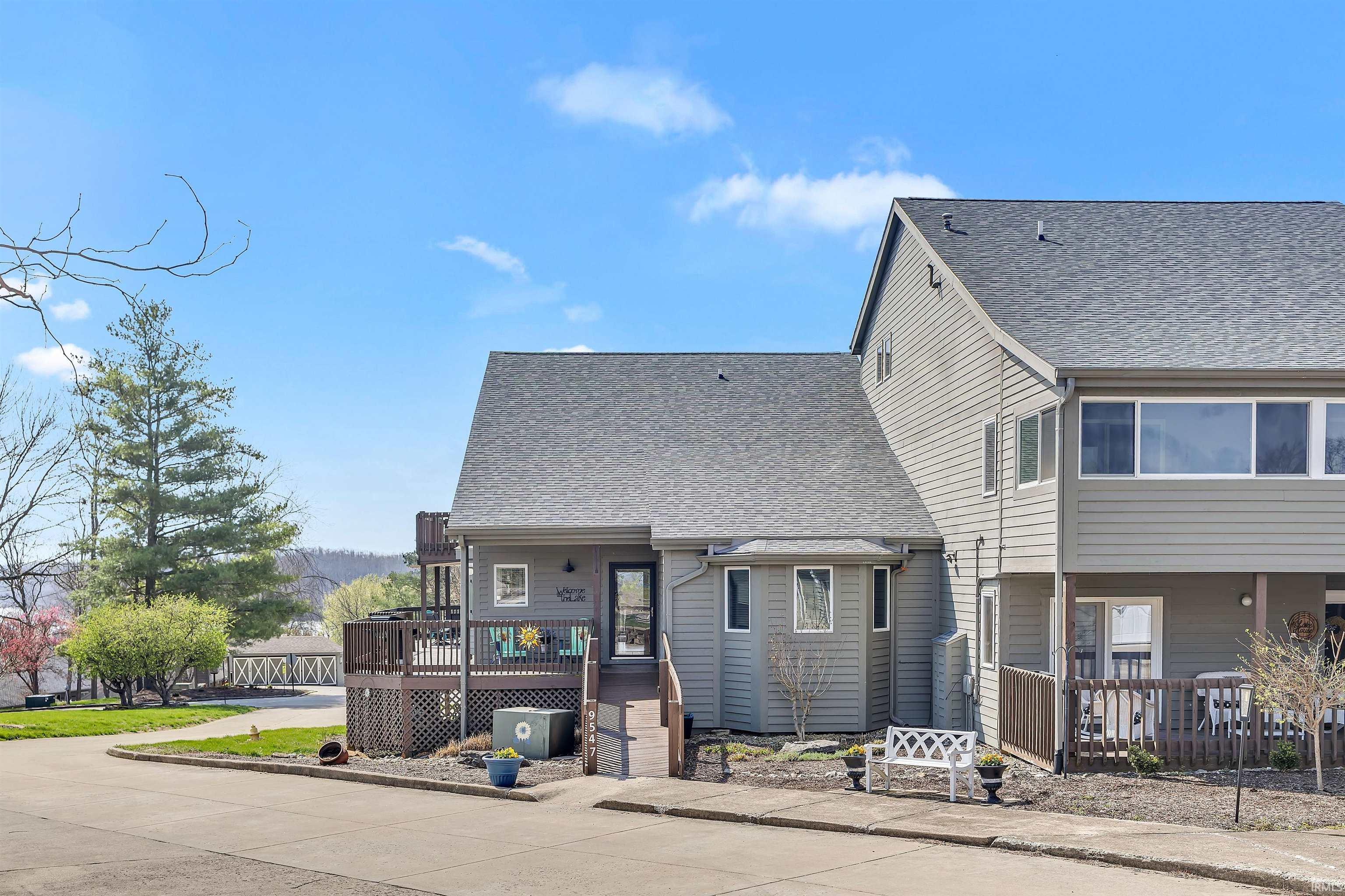 Image 1: View of front of house with a wooden deck and roof with shingles, Front Of Structure