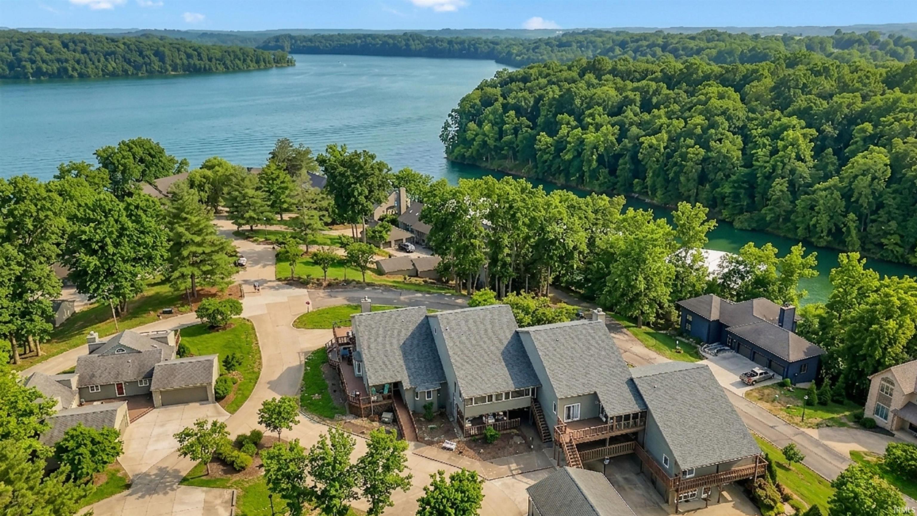 Image 3: Aerial perspective of suburban area featuring a nearby body of water and a forest, Aerial View