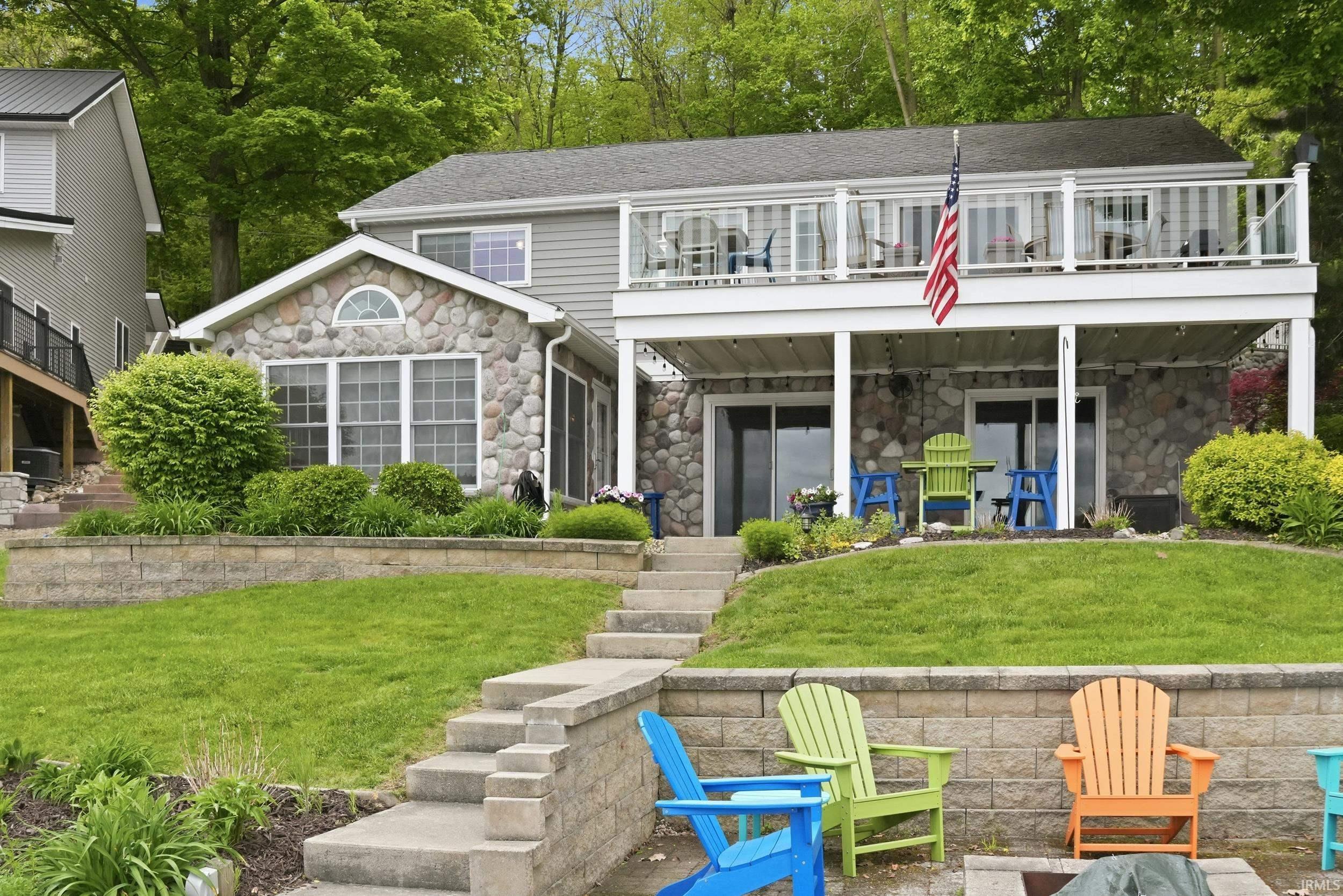 Image 0: Two-story residence featuring a stone and siding exterior, Back Of Structure