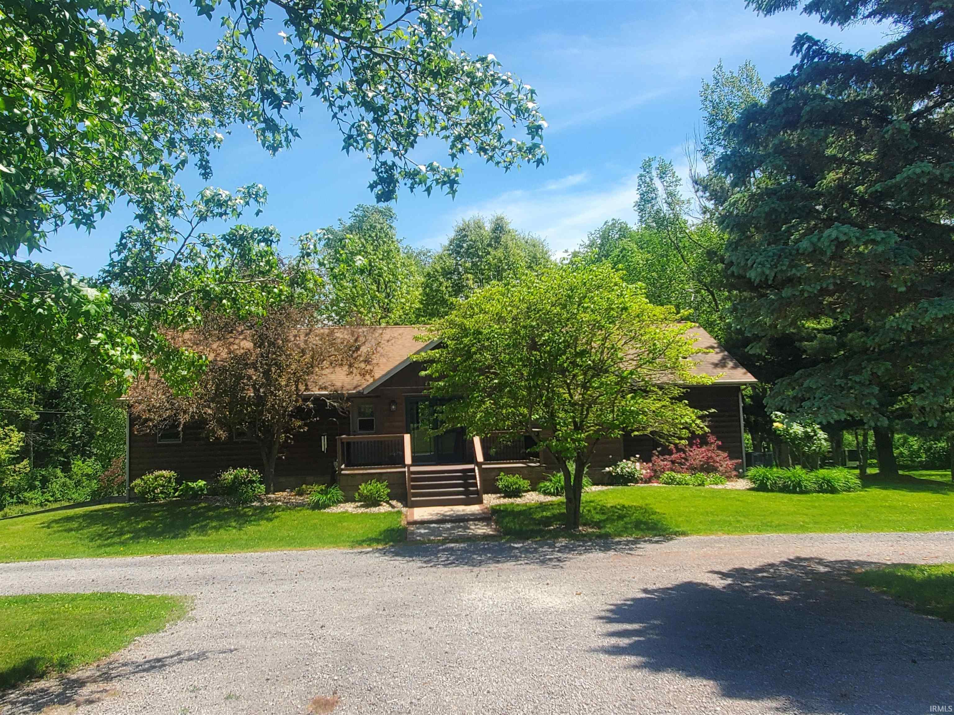 Image 3: Wood-sided home featuring an inviting front porch with dark wood railings, Front Of Structure Image 3: Wood-sided home featuring an inviting front porch with dark wood railings, Front Of Structure