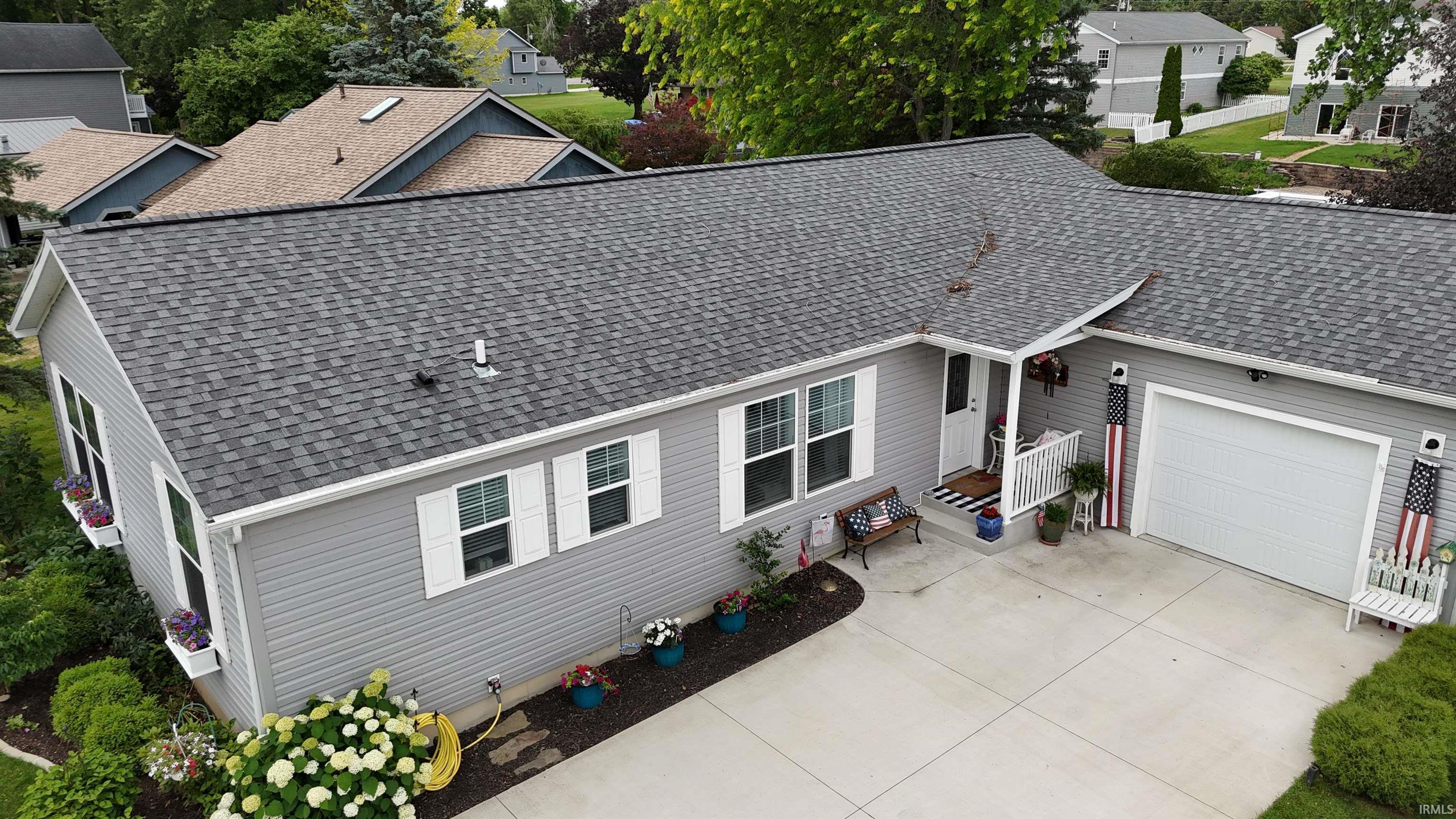 Image 0: Ranch-style residence featuring gray siding, a gray shingle roof, and white shutters, Front Of Structure Image 0: Ranch-style residence featuring gray siding, a gray shingle roof, and white shutters, Front Of Structure