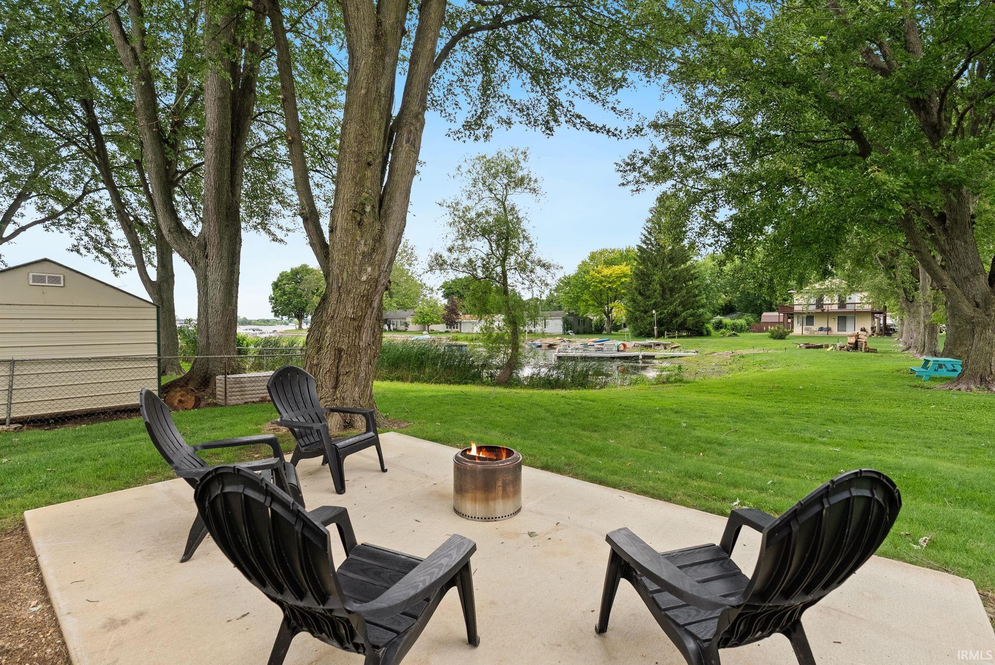 Image 3: Concrete patio area featuring a metal fire pit, Patio Image 3: Concrete patio area featuring a metal fire pit, Patio