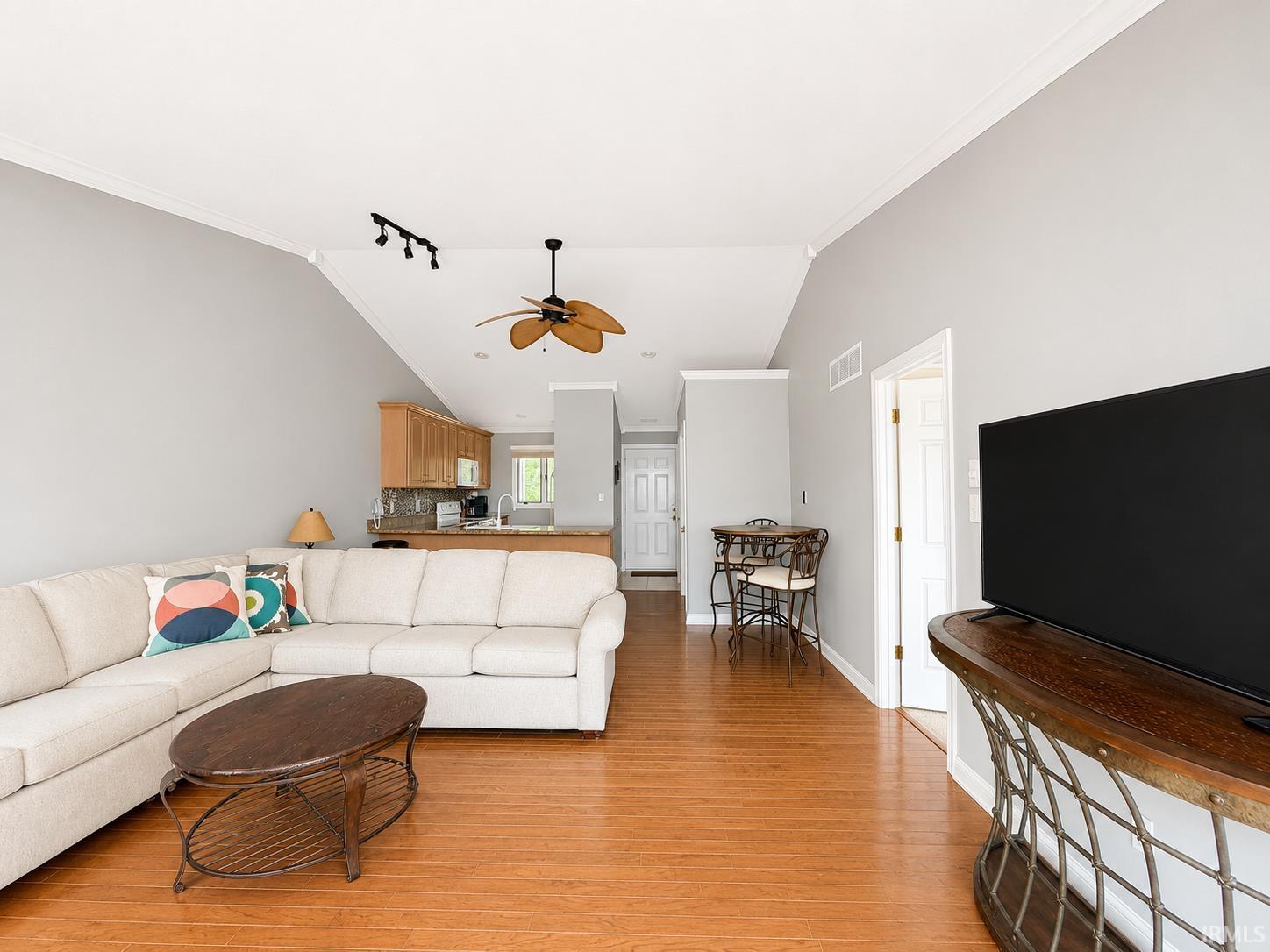 Image 3: Open-concept living space featuring wood-finish flooring, vaulted ceilings, and a ceiling fan, Living Room Image 3: Open-concept living space featuring wood-finish flooring, vaulted ceilings, and a ceiling fan, Living Room