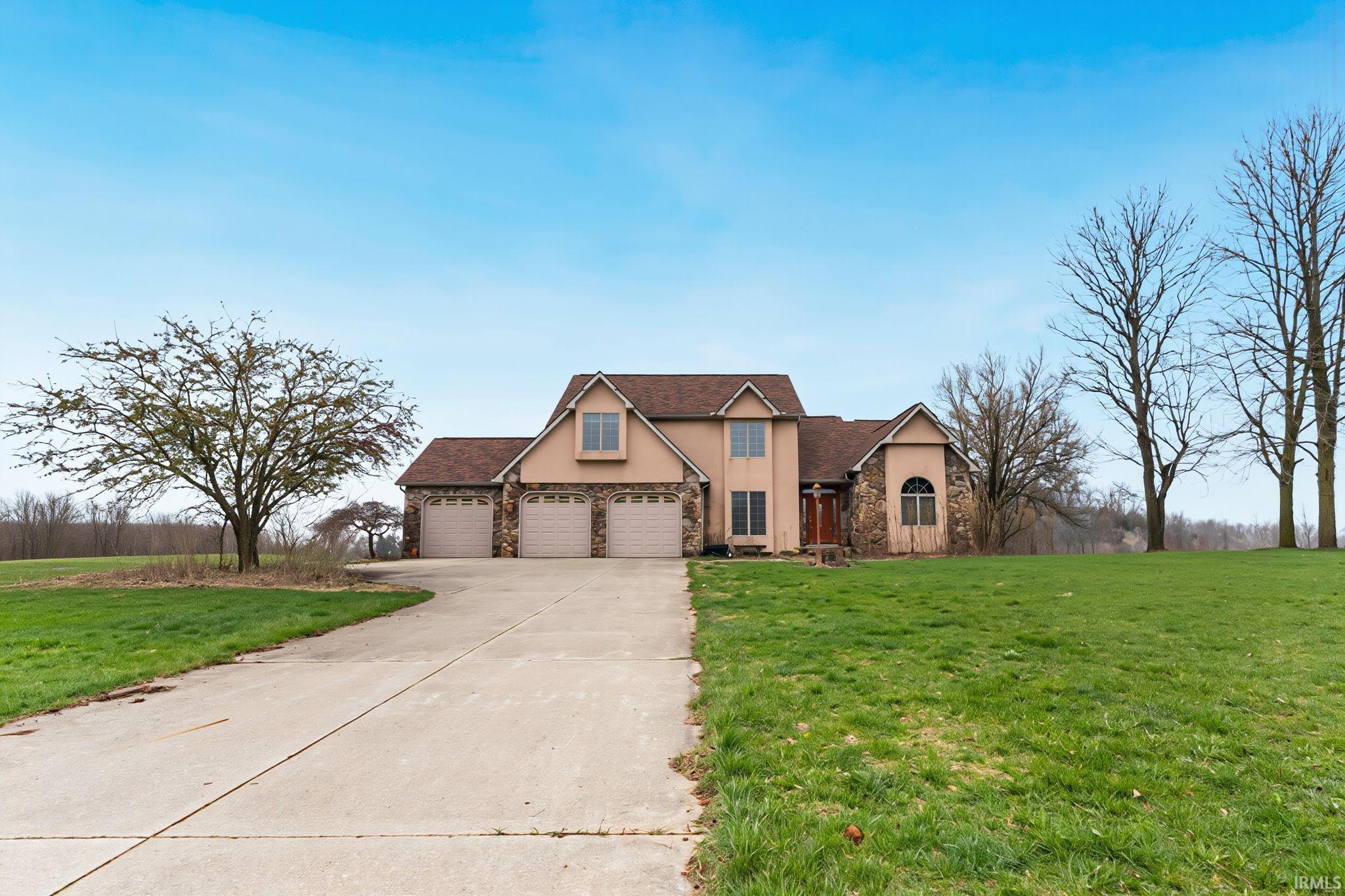 Image 2: Traditional-style house featuring a front lawn, stone siding, stucco siding, driveway, and a garage, Front Of Structure Image 2: Traditional-style house featuring a front lawn, stone siding, stucco siding, driveway, and a garage, Front Of Structure