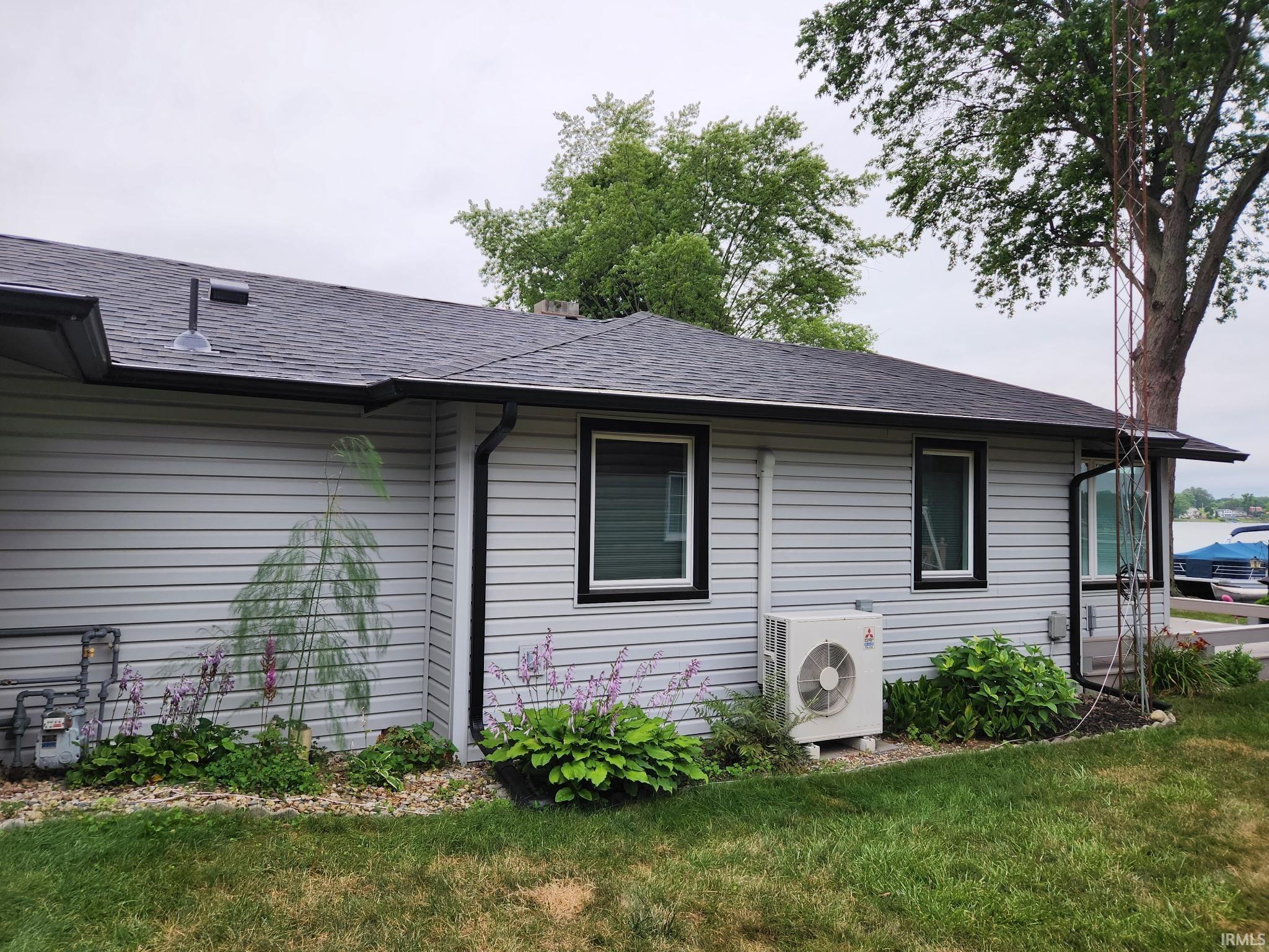 Image 3: View of home's exterior featuring roof with shingles and a yard, Side Of Structure