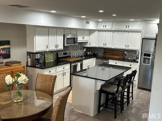 Image 3: Kitchen featuring stainless steel appliances, white cabinetry, a breakfast bar, and recessed lighting, Kitchen