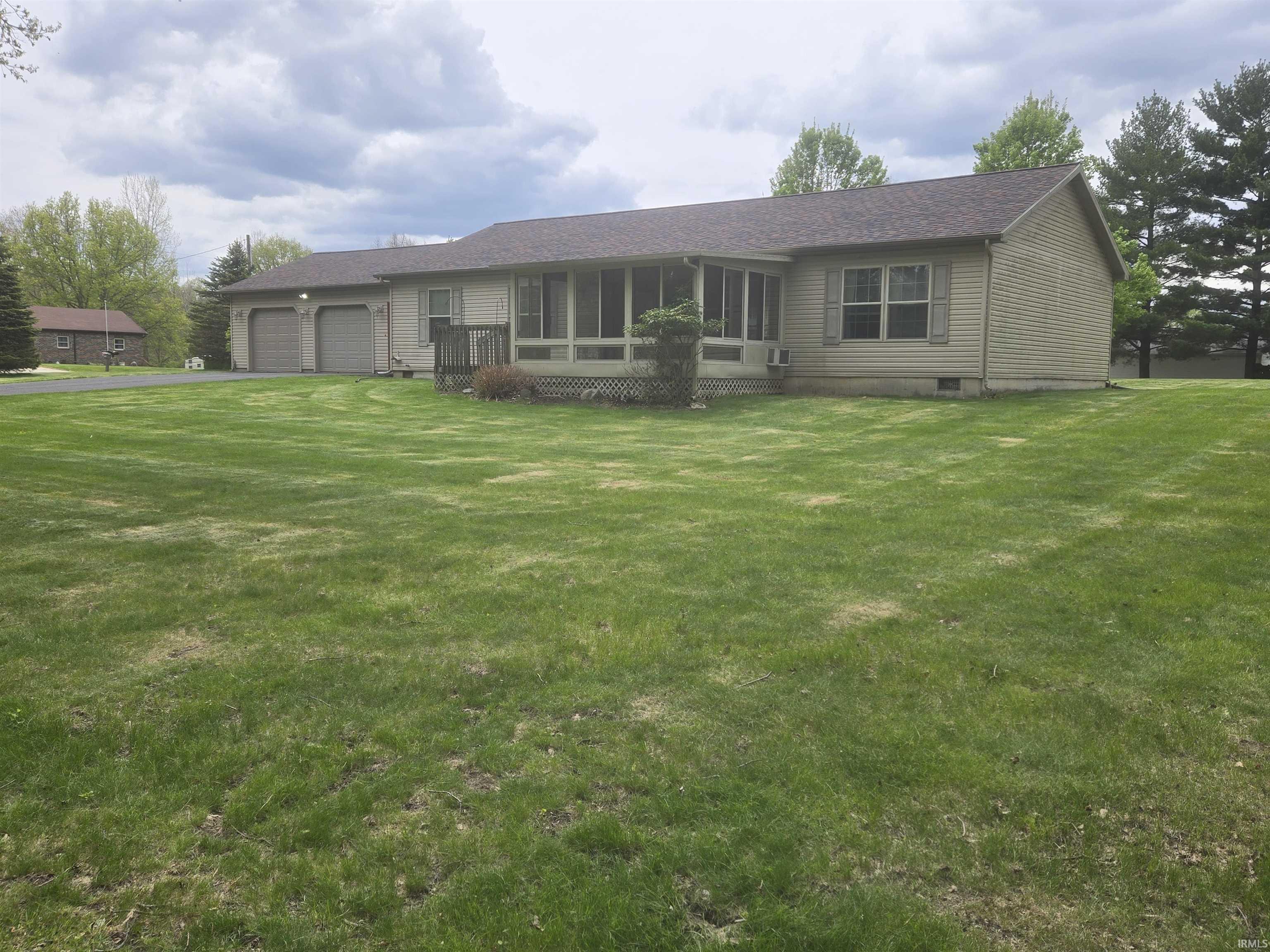Image 1: Spacious green lawn with a tan siding residence, Front Of Structure