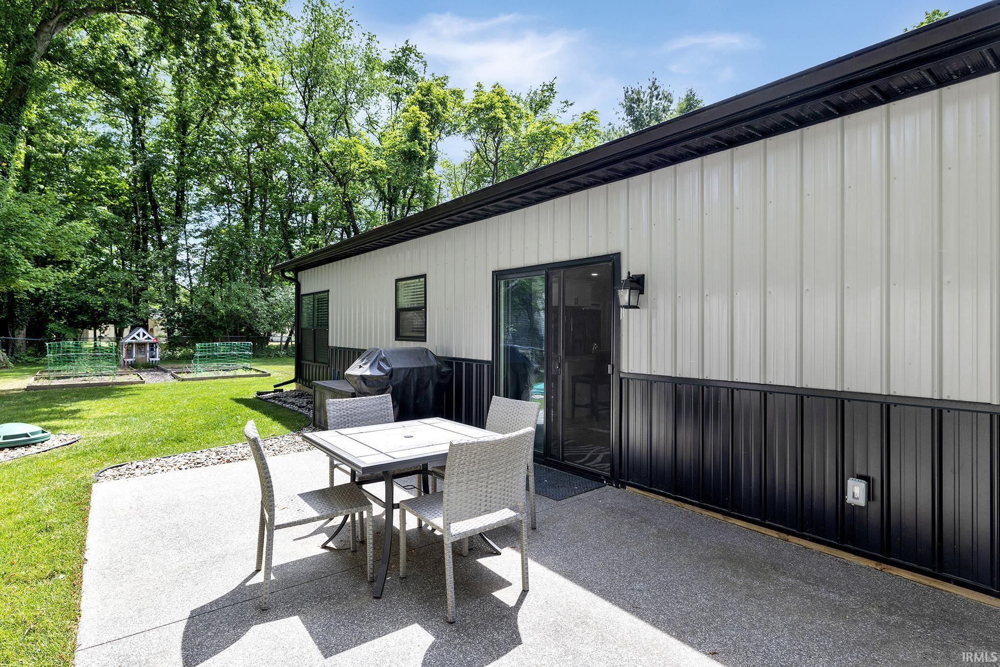 Image 3: Concrete patio and expansive lawn featuring mature trees, Patio