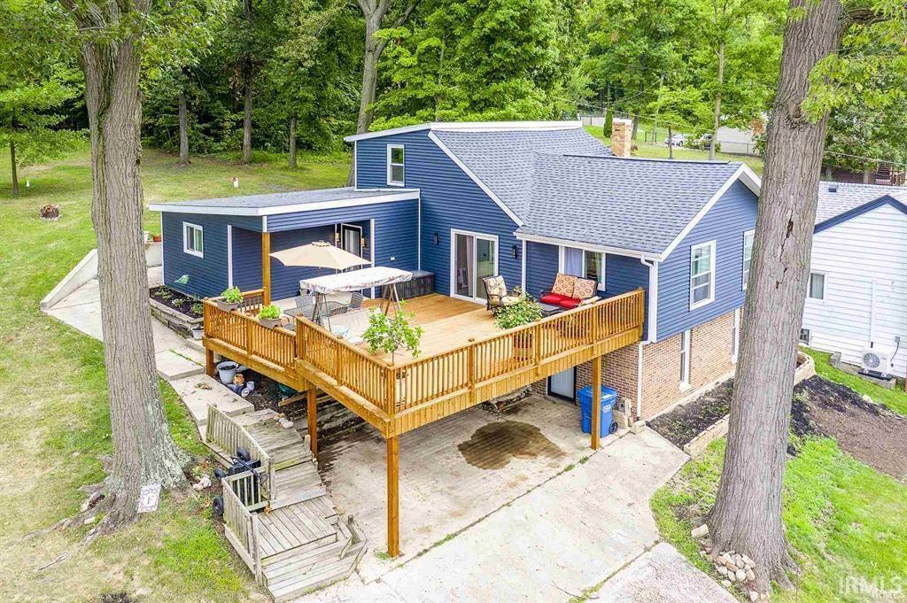Image 0: View of front facade with a wooden deck, roof with shingles, a front yard, and a patio area, Front Of Structure