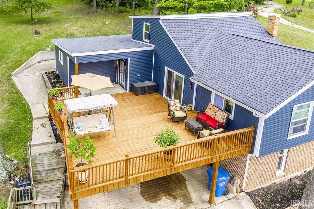 Image 1: Front of house featuring a deck, outdoor dining area, and roof with shingles, Deck
