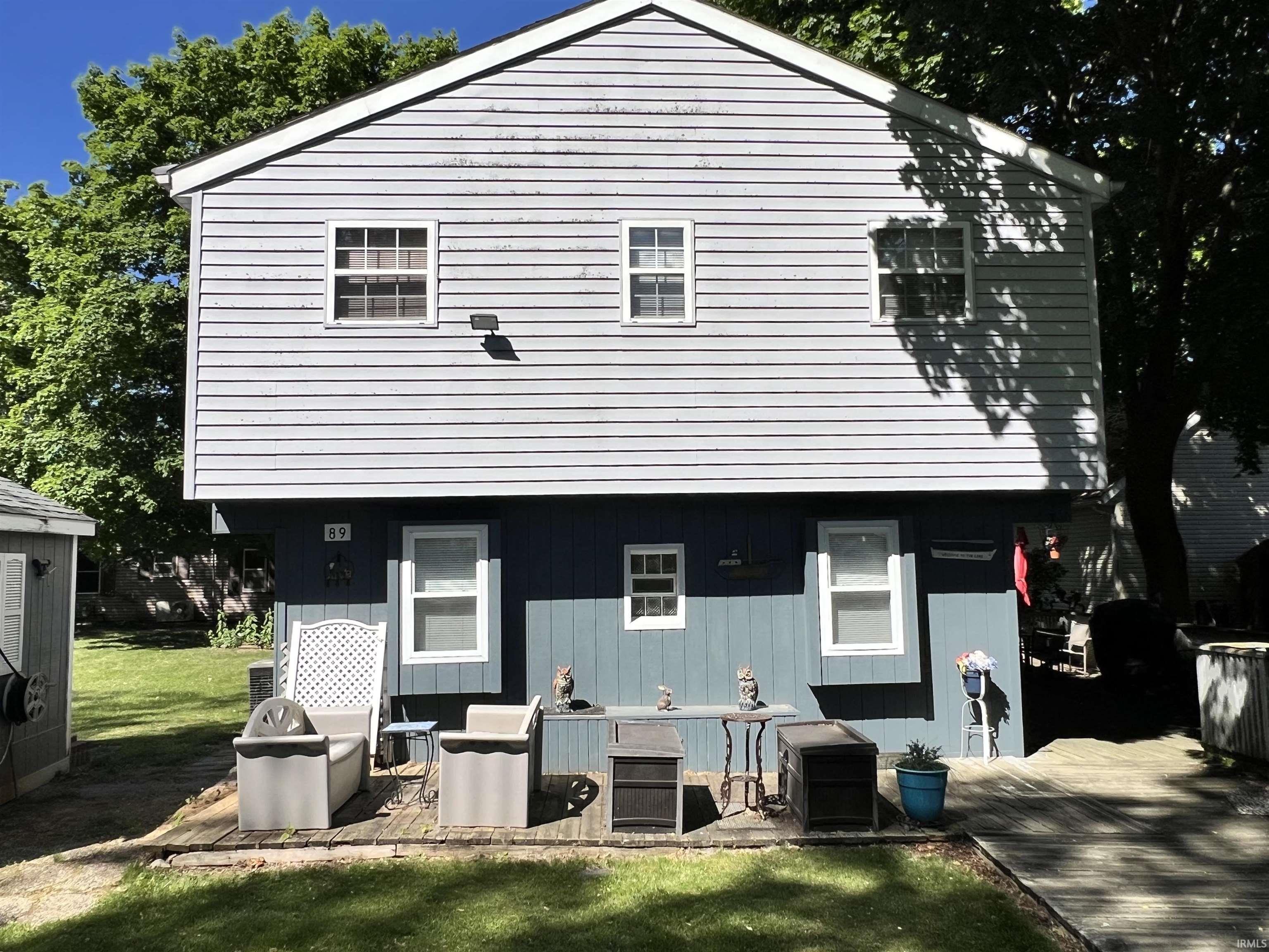 Image 0: Two-story residence featuring light blue siding on the upper level and a darker blue siding on the lower level, Back Of Structure Image 0: Two-story residence featuring light blue siding on the upper level and a darker blue siding on the lower level, Back Of Structure