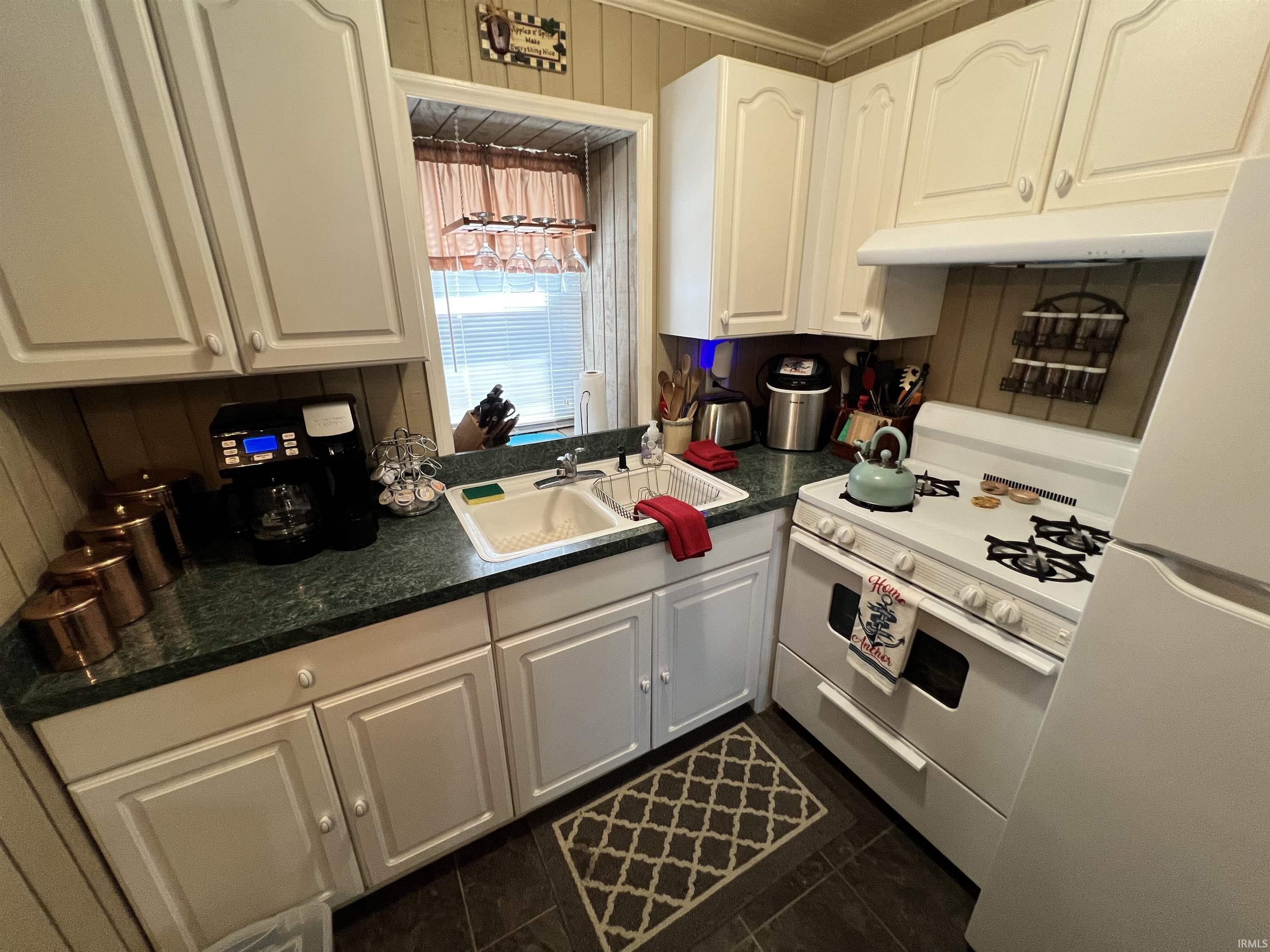Image 2: Kitchen featuring white cabinetry, a double basin sink, green countertop, and dark flooring, Kitchen Image 2: Kitchen featuring white cabinetry, a double basin sink, green countertop, and dark flooring, Kitchen