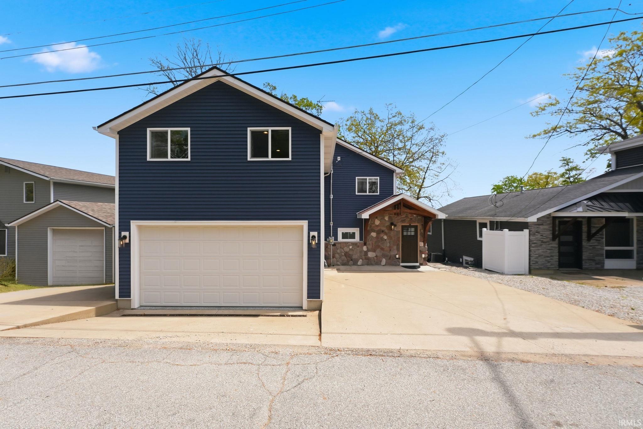Image 2: Contemporary two-story home featuring dark blue horizontal siding and a two-car garage, Front Of Structure Image 2: Contemporary two-story home featuring dark blue horizontal siding and a two-car garage, Front Of Structure