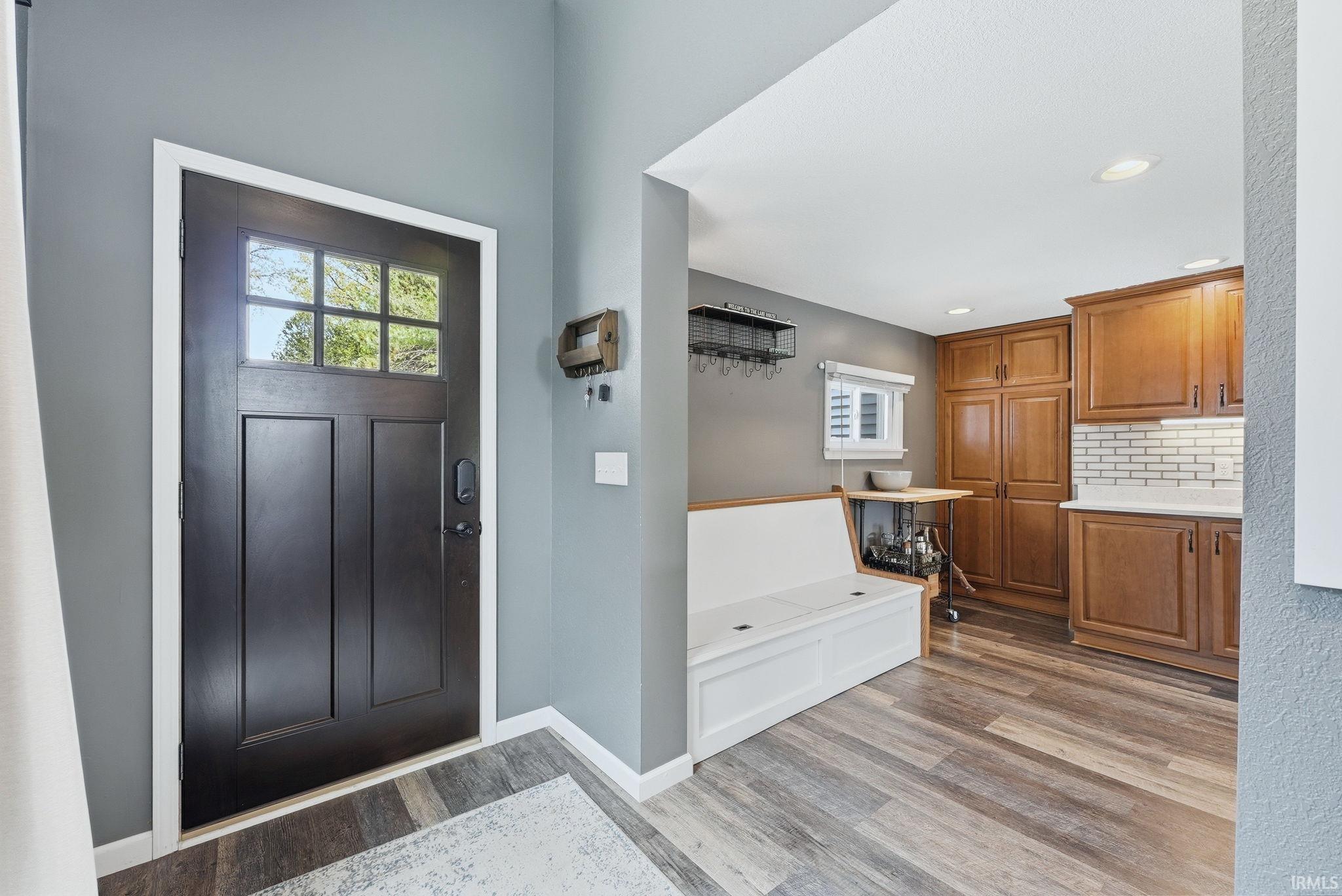 Image 3: Front entry with dark paneled door featuring multiple glass lites and a smart lock, Entrance Foyer Image 3: Front entry with dark paneled door featuring multiple glass lites and a smart lock, Entrance Foyer