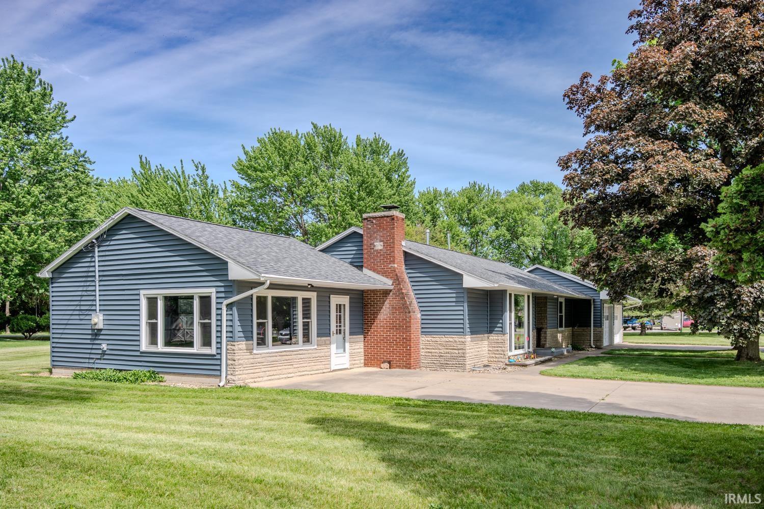 Image 0: Ranch-style residence featuring blue horizontal siding and a stone facade, Front Of Structure Image 0: Ranch-style residence featuring blue horizontal siding and a stone facade, Front Of Structure