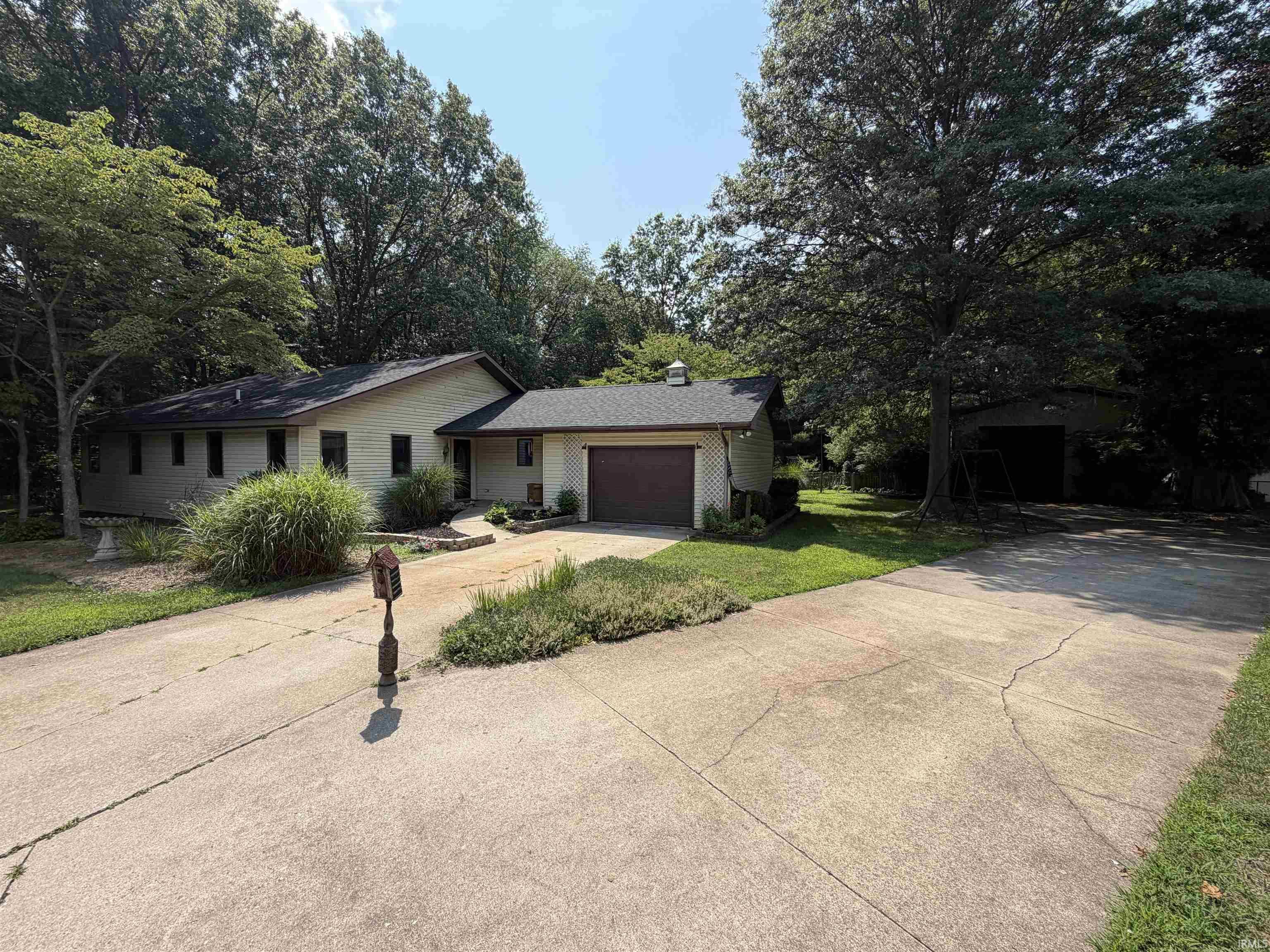Image 2: Single-story residence featuring light-colored siding, an attached single-car garage, and a dark shingle roof, Front Of Structure Image 2: Single-story residence featuring light-colored siding, an attached single-car garage, and a dark shingle roof, Front Of Structure